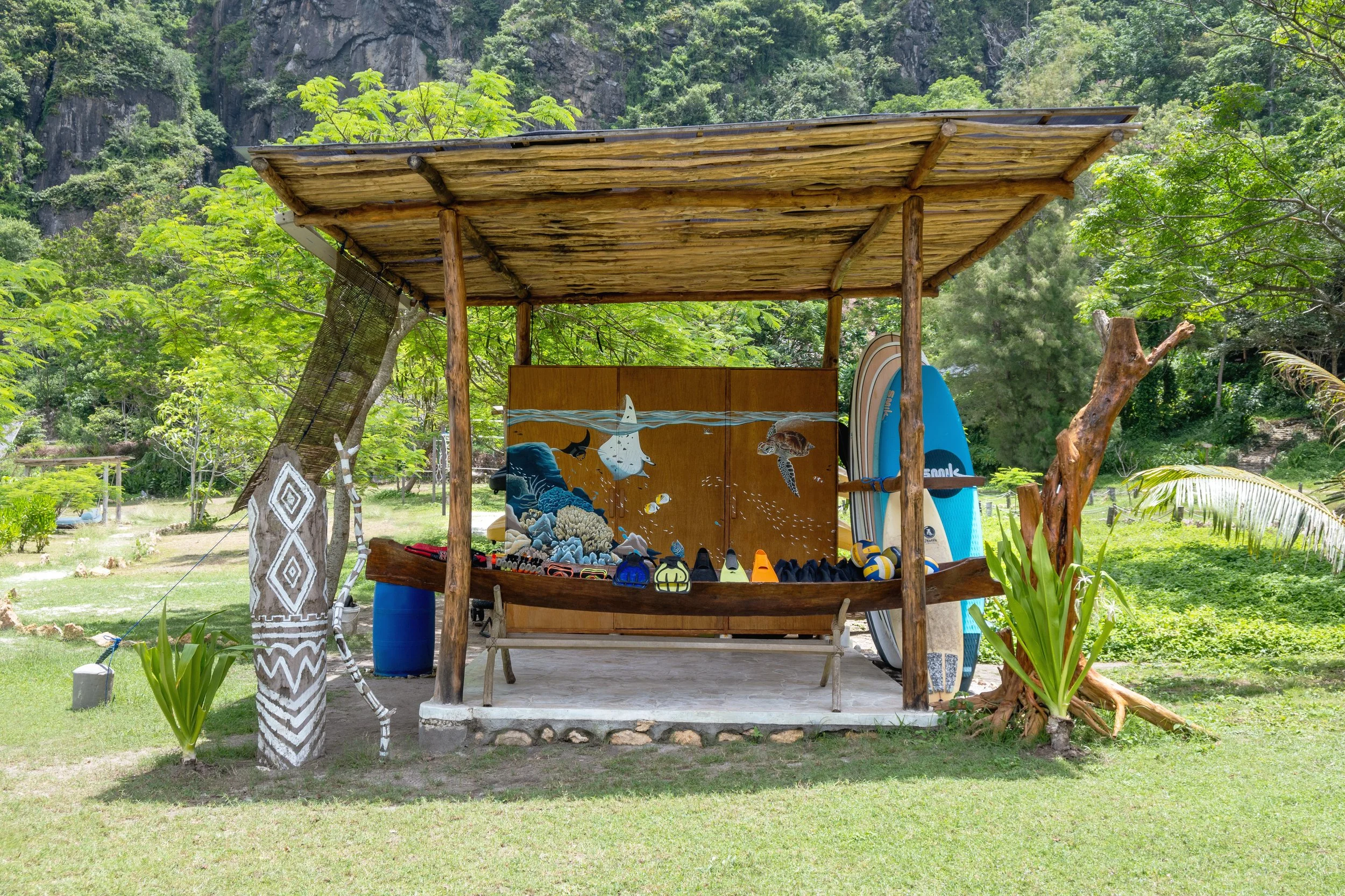 Kirana Retreat - A lively underwater scene featuring a variety of marine species. Painted on a wooden closet used to store watersport equipment at the resorts  watersport centre.