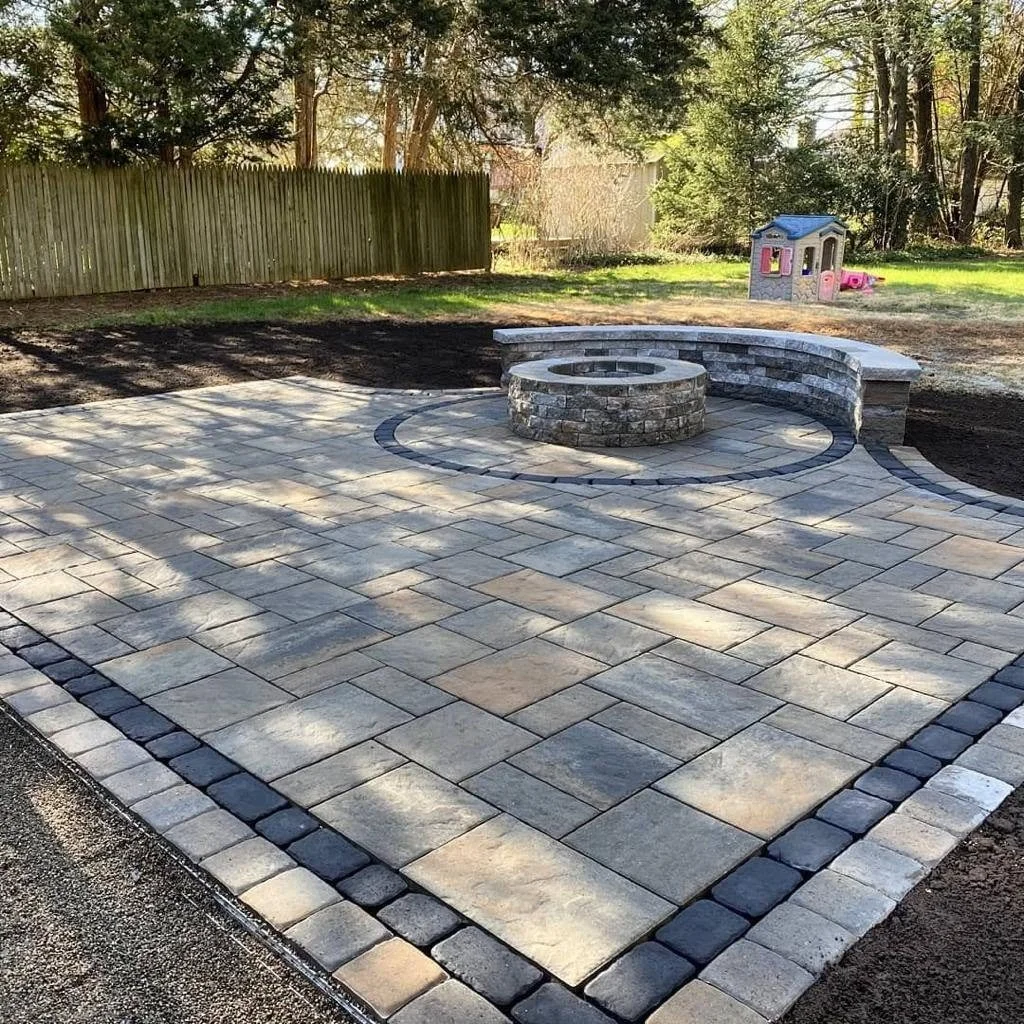 DAZA paver patio with a round fire pit and curved stone seating wall