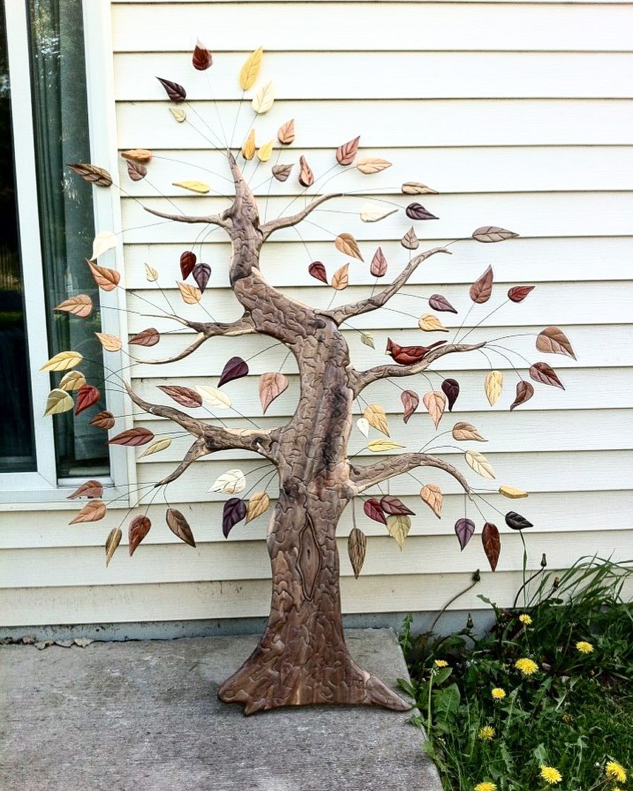 The first tree I ever made was nearly ten years ago! The trunk is walnut, leaves are various species of wood (all natural colors&mdash;- I don&rsquo;t add any stains), and the cardinal is made from redheart, ebony and chakte viga woods. Each leaf con