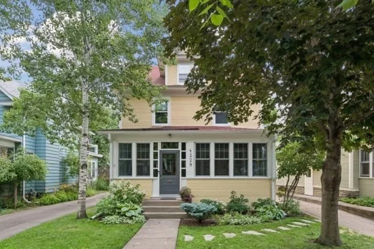 Beautiful three story yellow east harriet home with large front porch