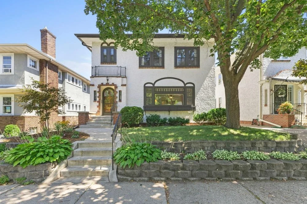 Stucco two story duplex in east harriet, beatifully maintained garden out front.