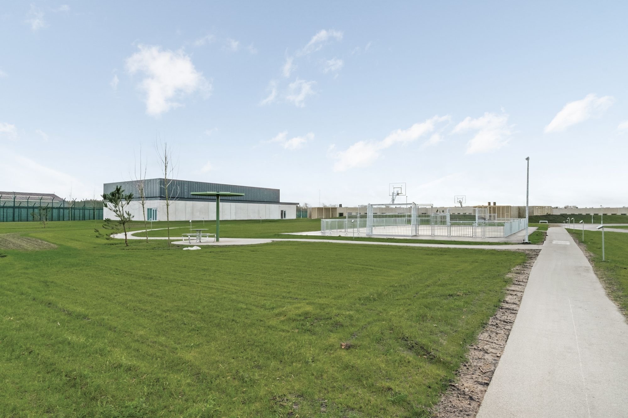 Exterior view of the sports building and outdoor court at Sønder Omme Prison