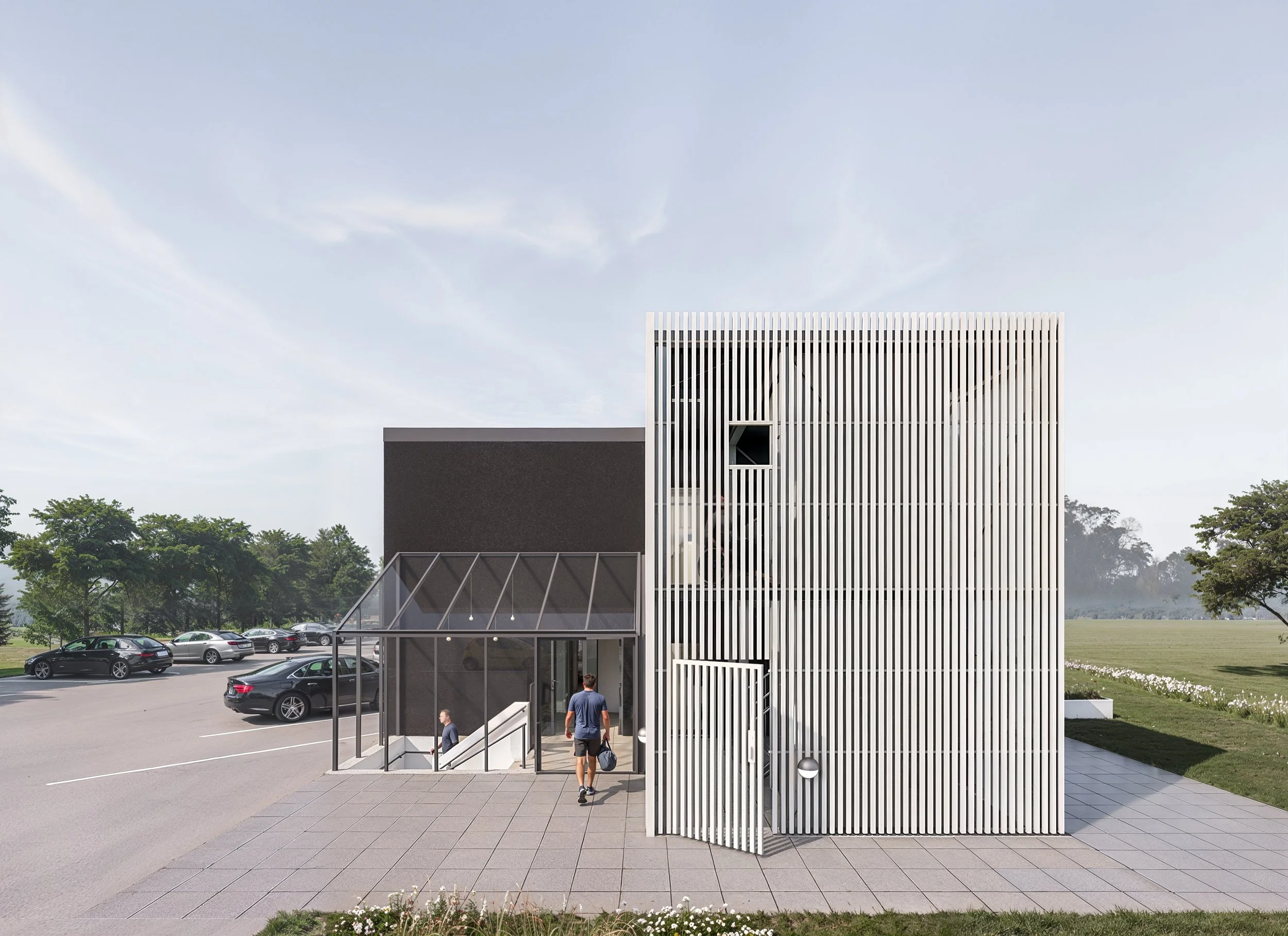 Hovedindgang med glasoverdækket trappe ny beplantning og organiseret parkering