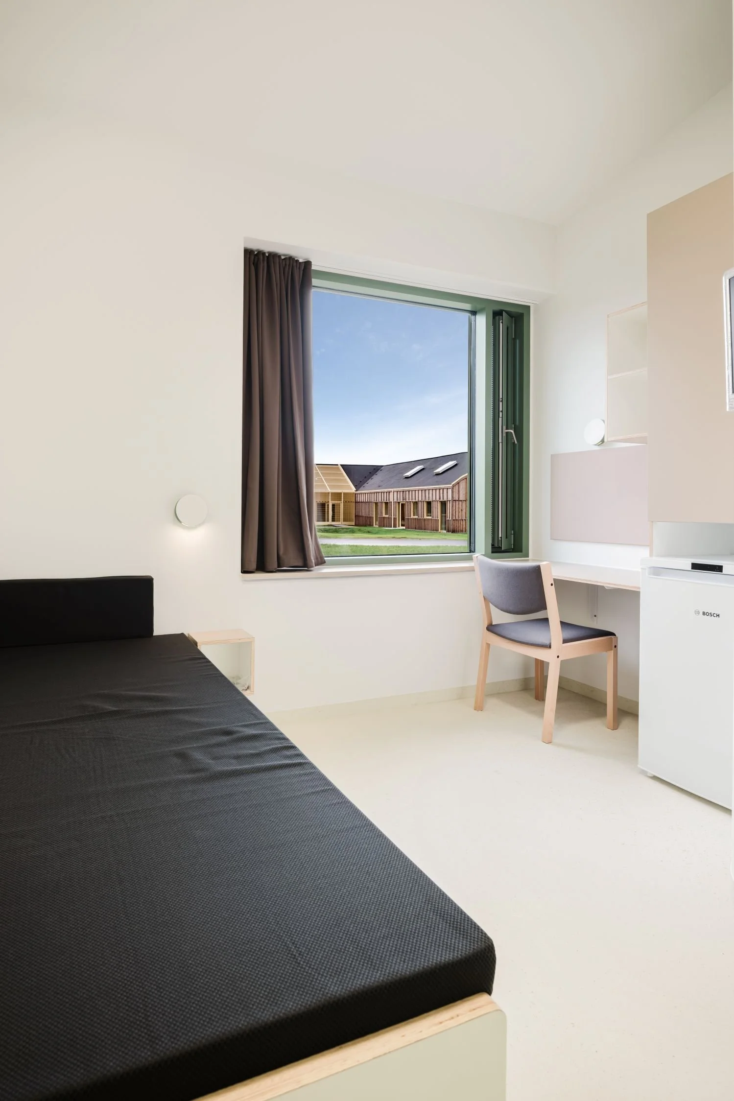 Interior view of a prison cell at Sønder Omme Prison with bed and desk