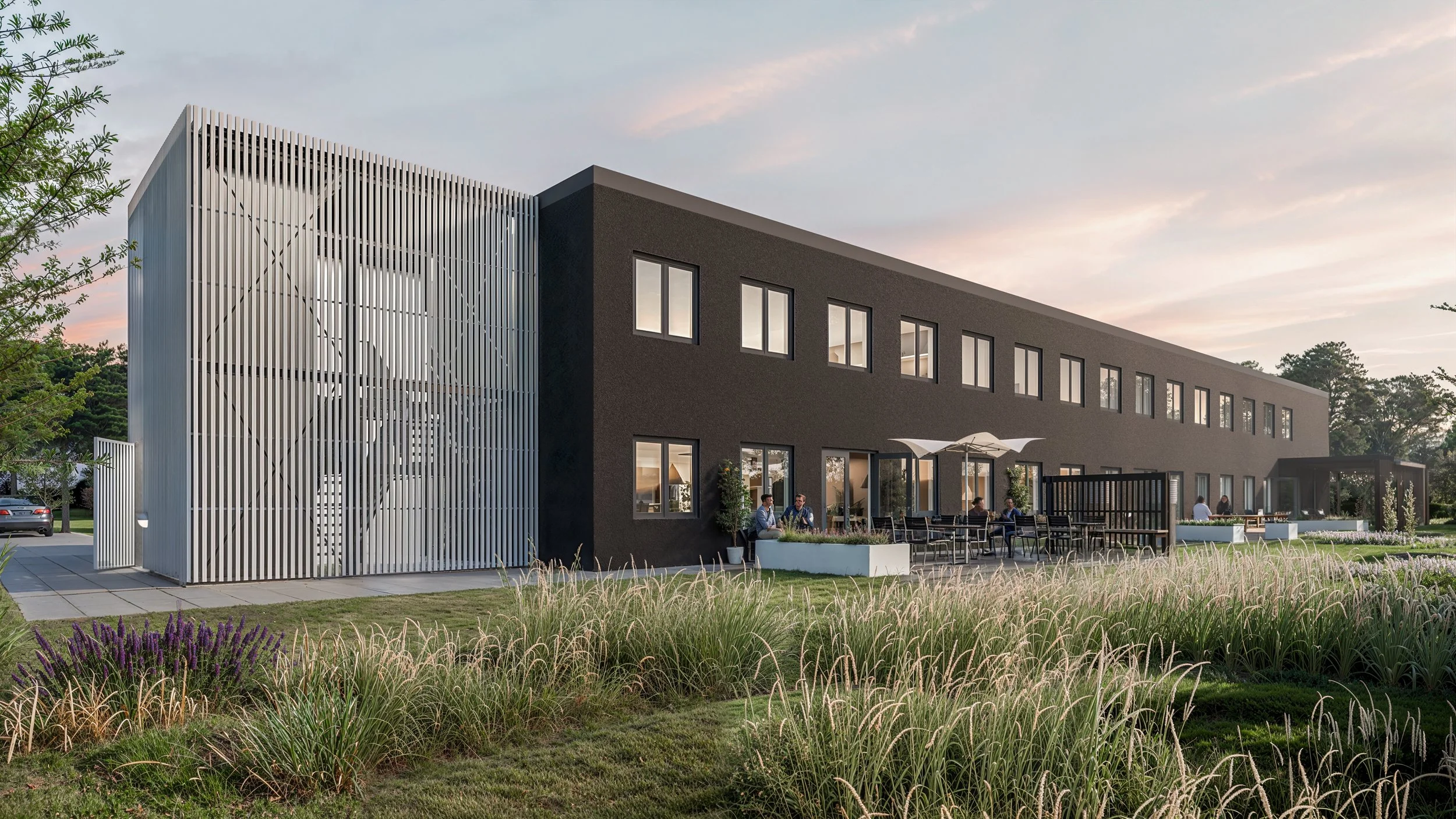 Elevator og nødtrappe med lamelstruktur der filtrerer lys og skaber tryg adgang.