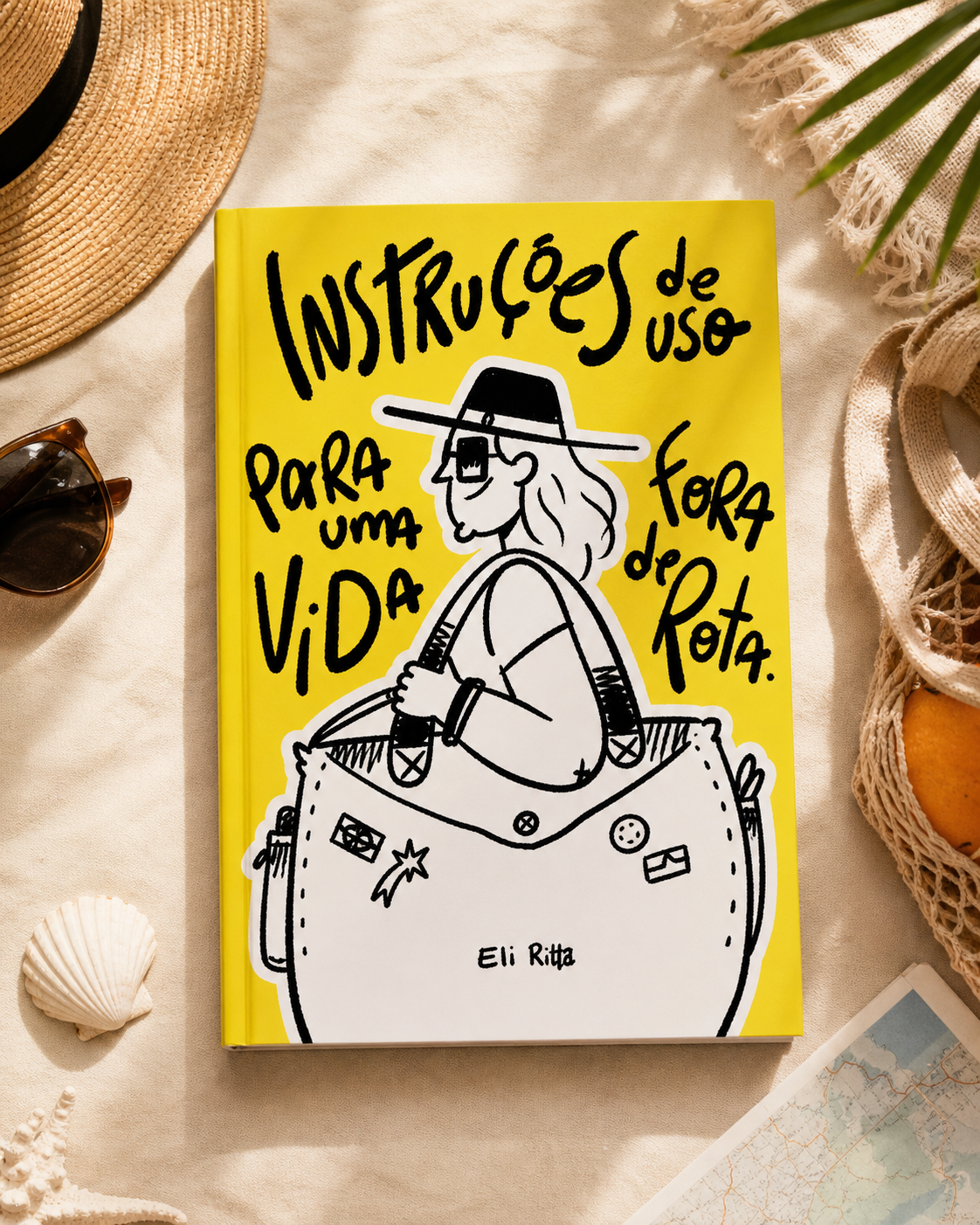 A book titled 'Instruções de uso para uma vida fora de rota' by Eli Ritta on a beige surface surrounded by summer items like sunglasses, a straw hat, a shell, and a map.