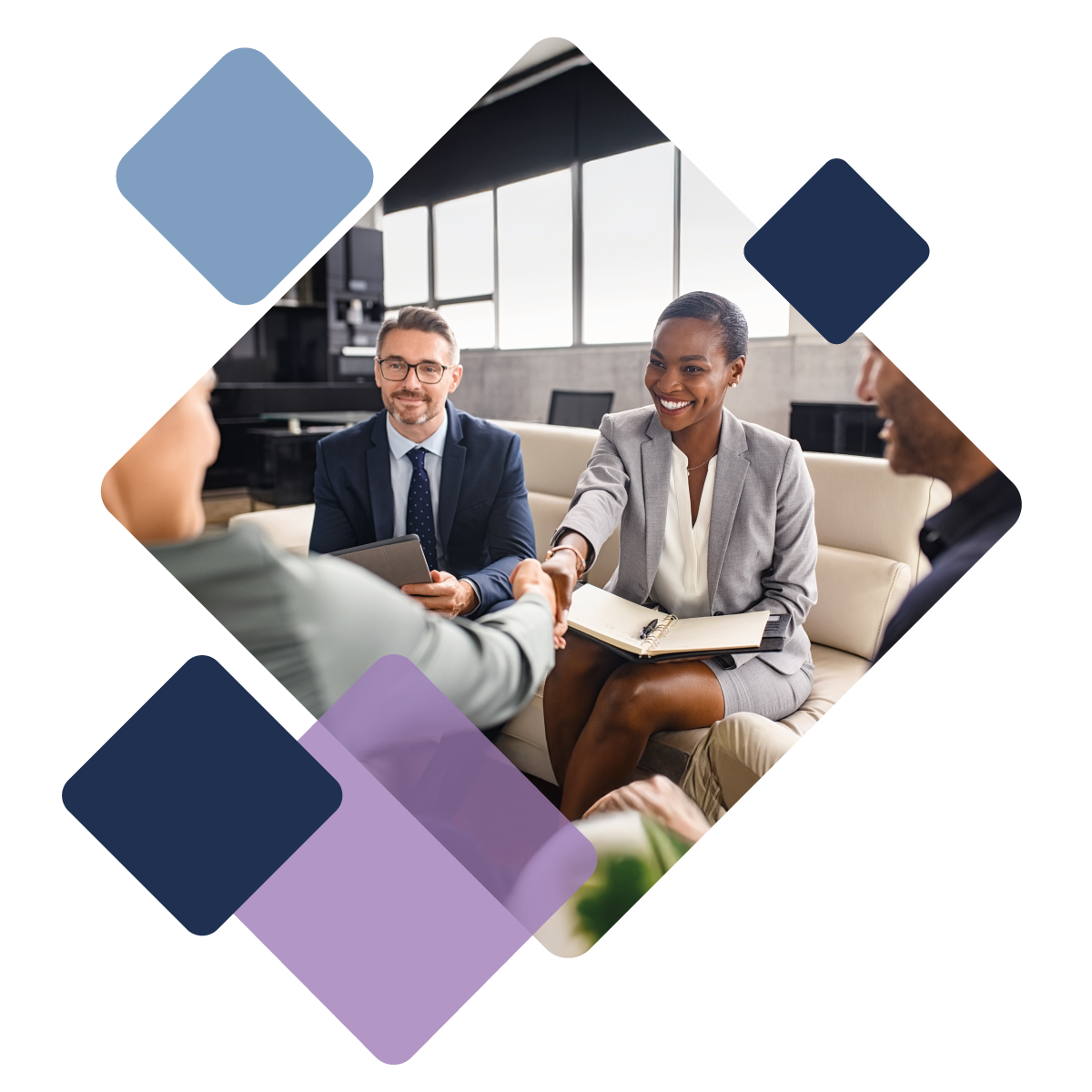 Businesspeople shaking hands in an office meeting, smiling and exchanging documents.
