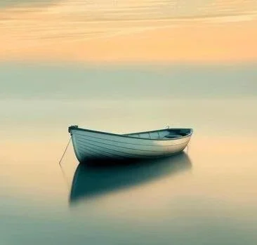 A small white boat floating on calm water at sunset with pastel-colored sky.