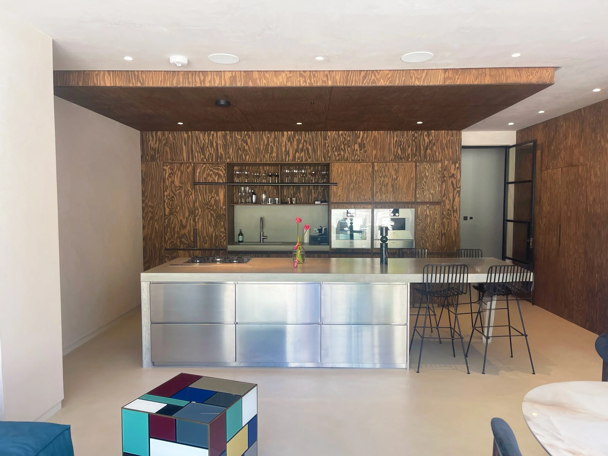 Modern kitchen extension with wood panelling, industrial steel island, crittall doors.