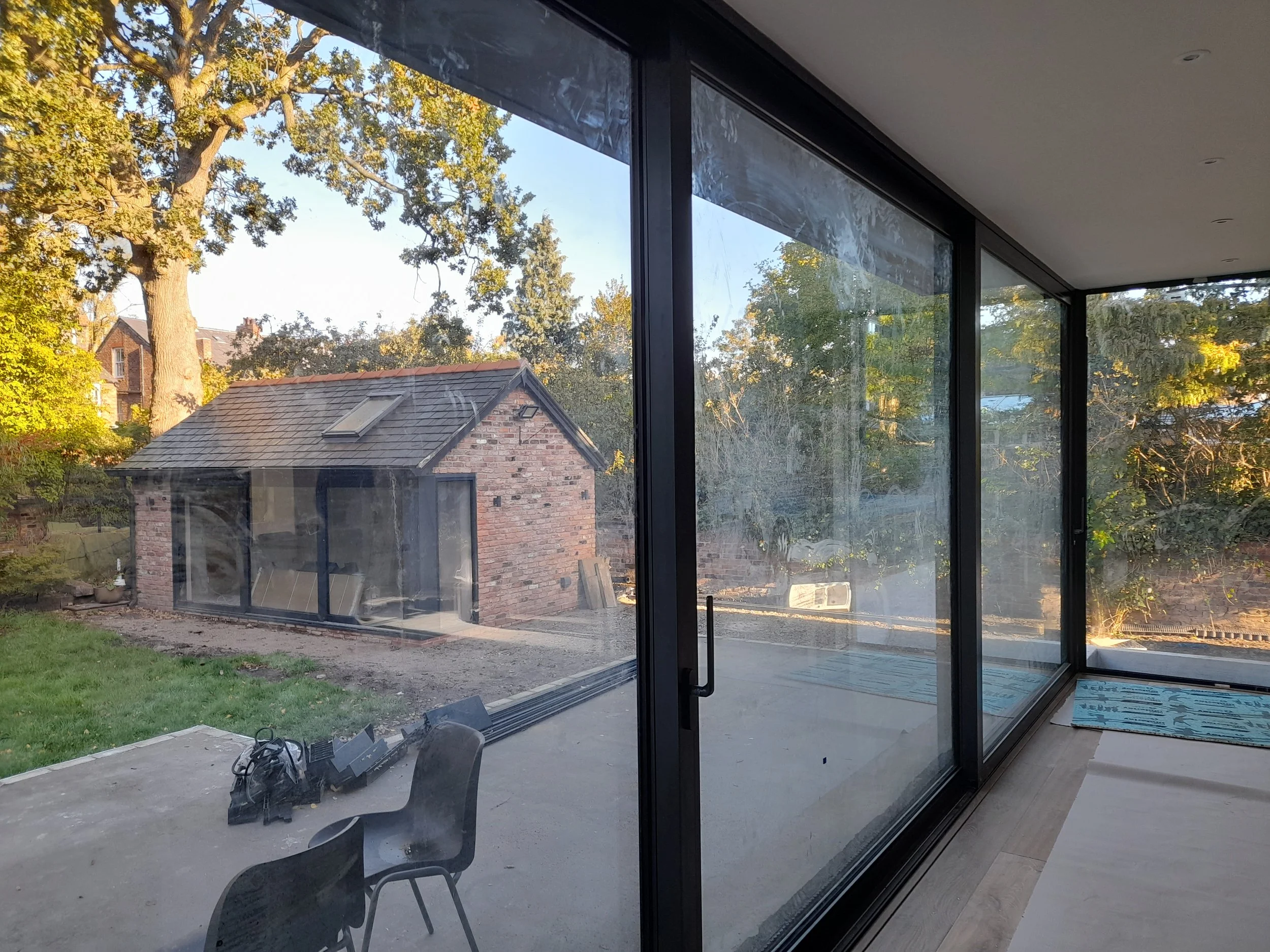 Interior construction progress showing exposed steel beams during modern rear extension build in West Didsbury, Manchester.