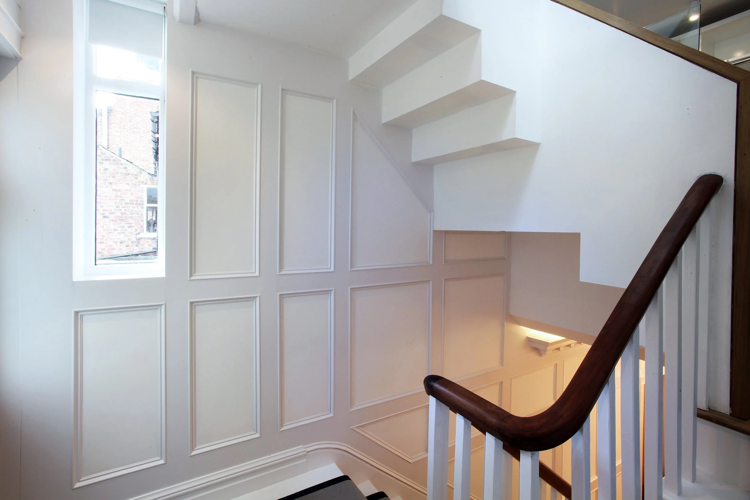 Contemporary oak staircase with detailed panelling in refurbished Manchester home extension and loft conversion.