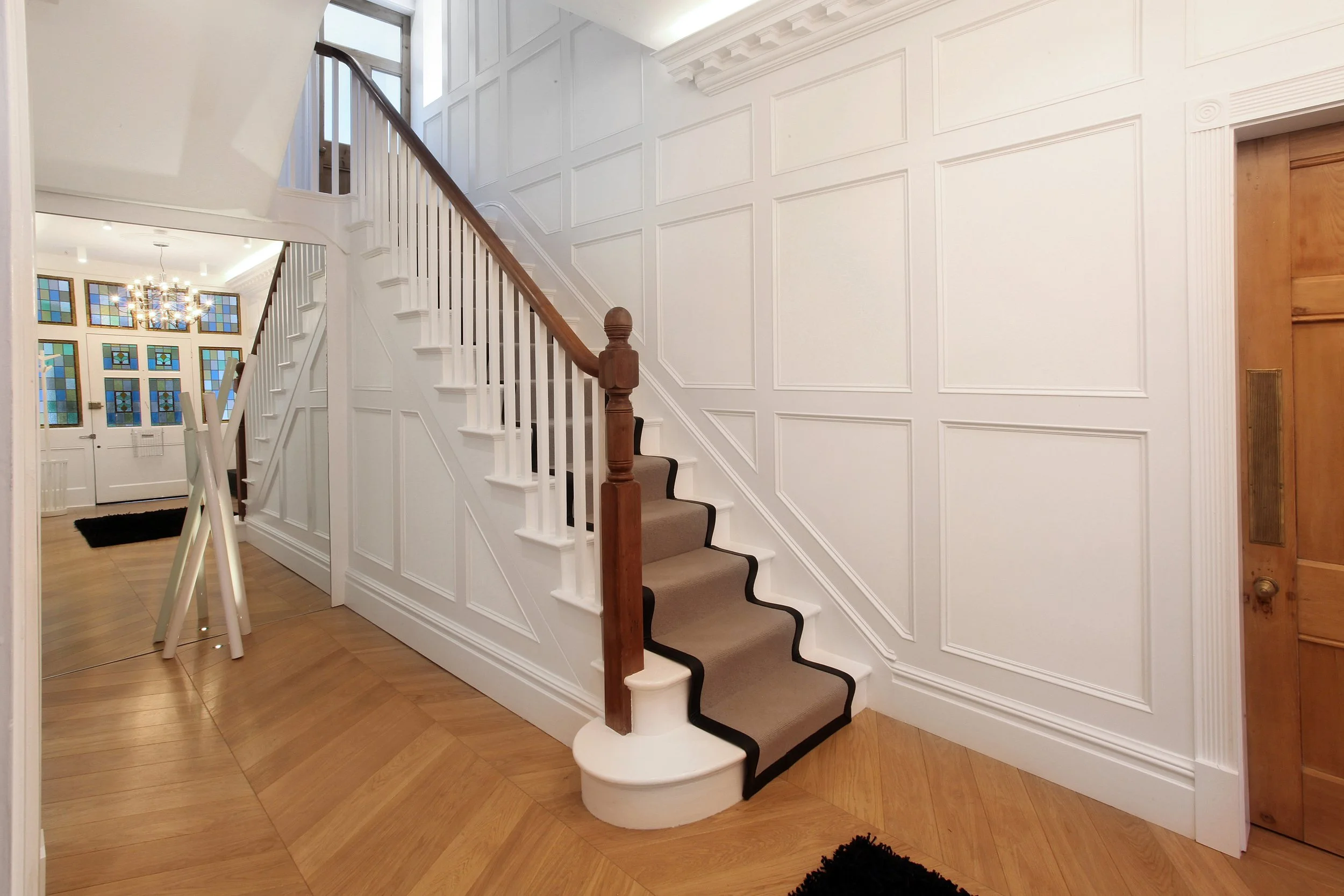 Oak staircase with panelled walls, traditional balustrade linking refurbished Victorian floors in West Didsbury Victorian house renovation.