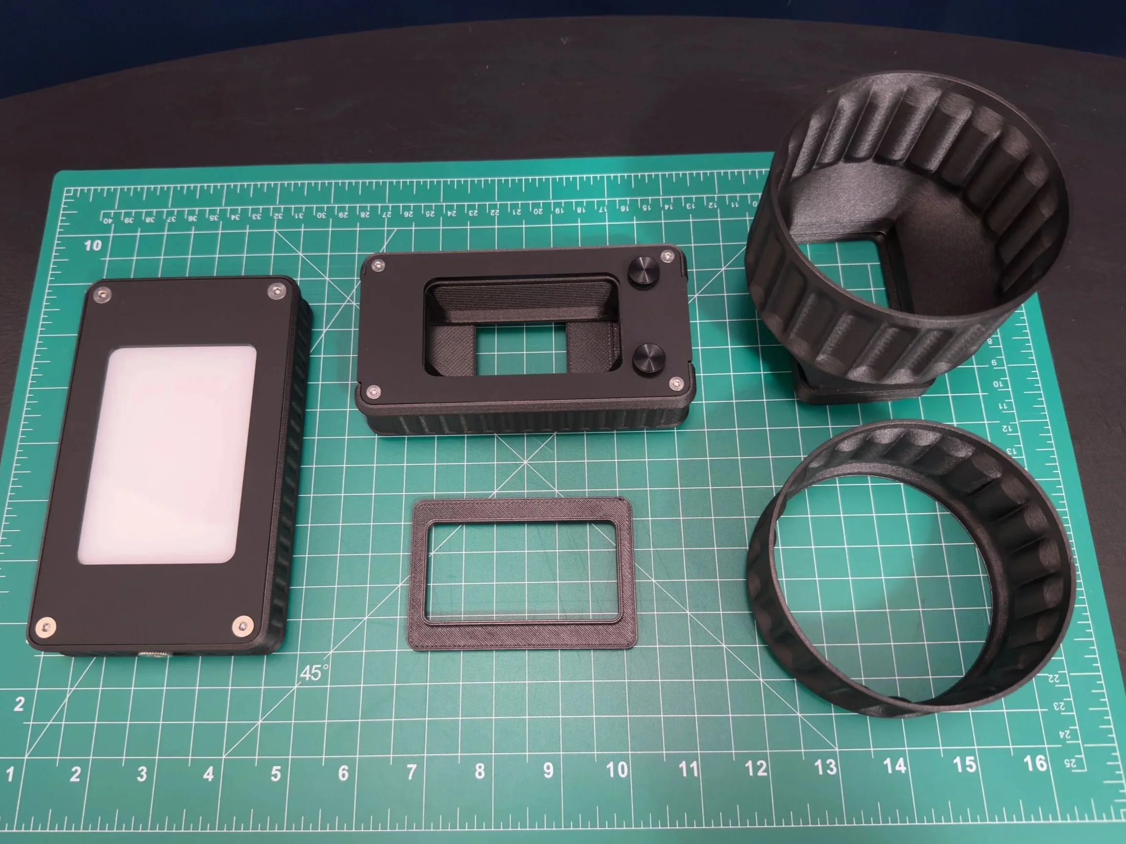 Light Source 35, Basic Film Carrier 35 MK2, Light Source Adapter, Film Scanning Hood sitting on a green self-healing cutting mat.