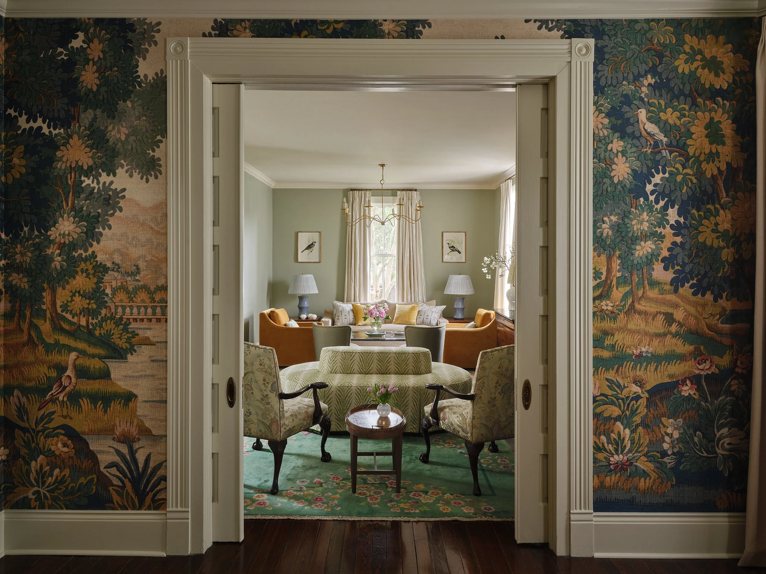 Dining room entryway with wooden sliding doors, showing a view of a traditional living room. 