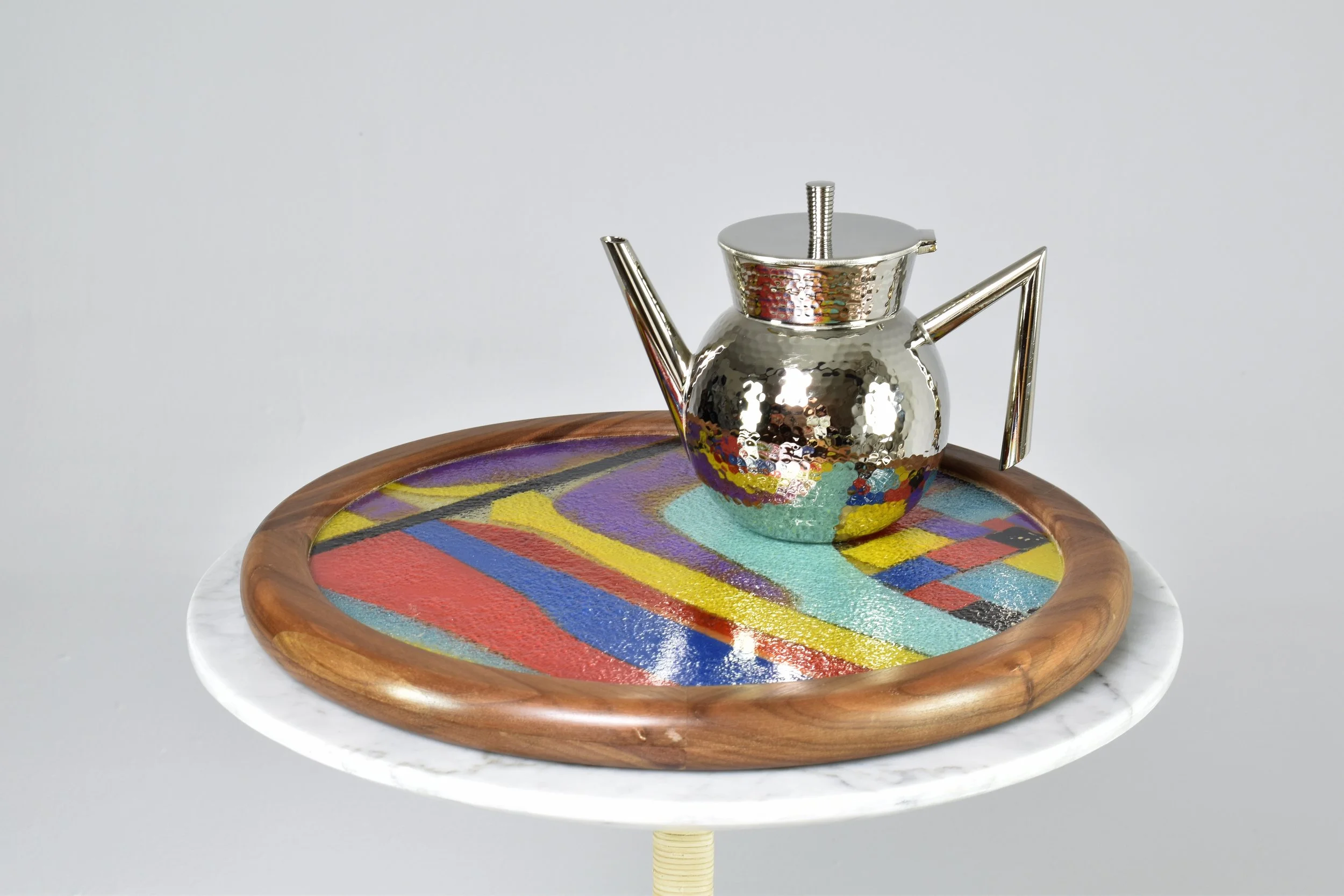 decorative round tray with a colorful mosaic design inside, surrounded by a wooden border and metal handles.