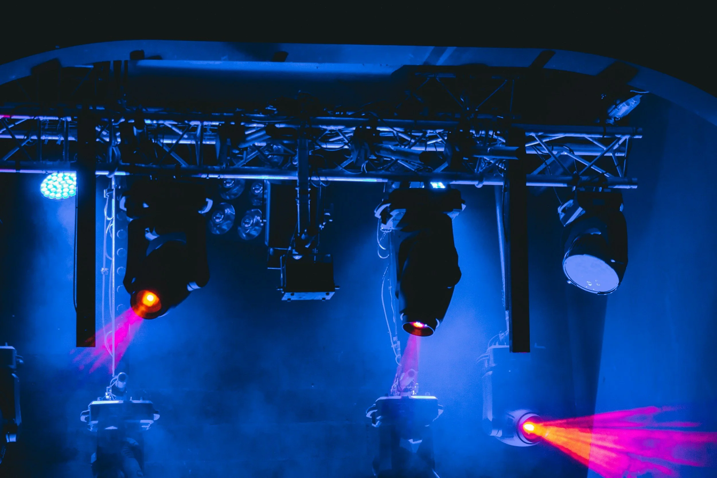 Stage lighting equipment in a dark room with blue and red lights.