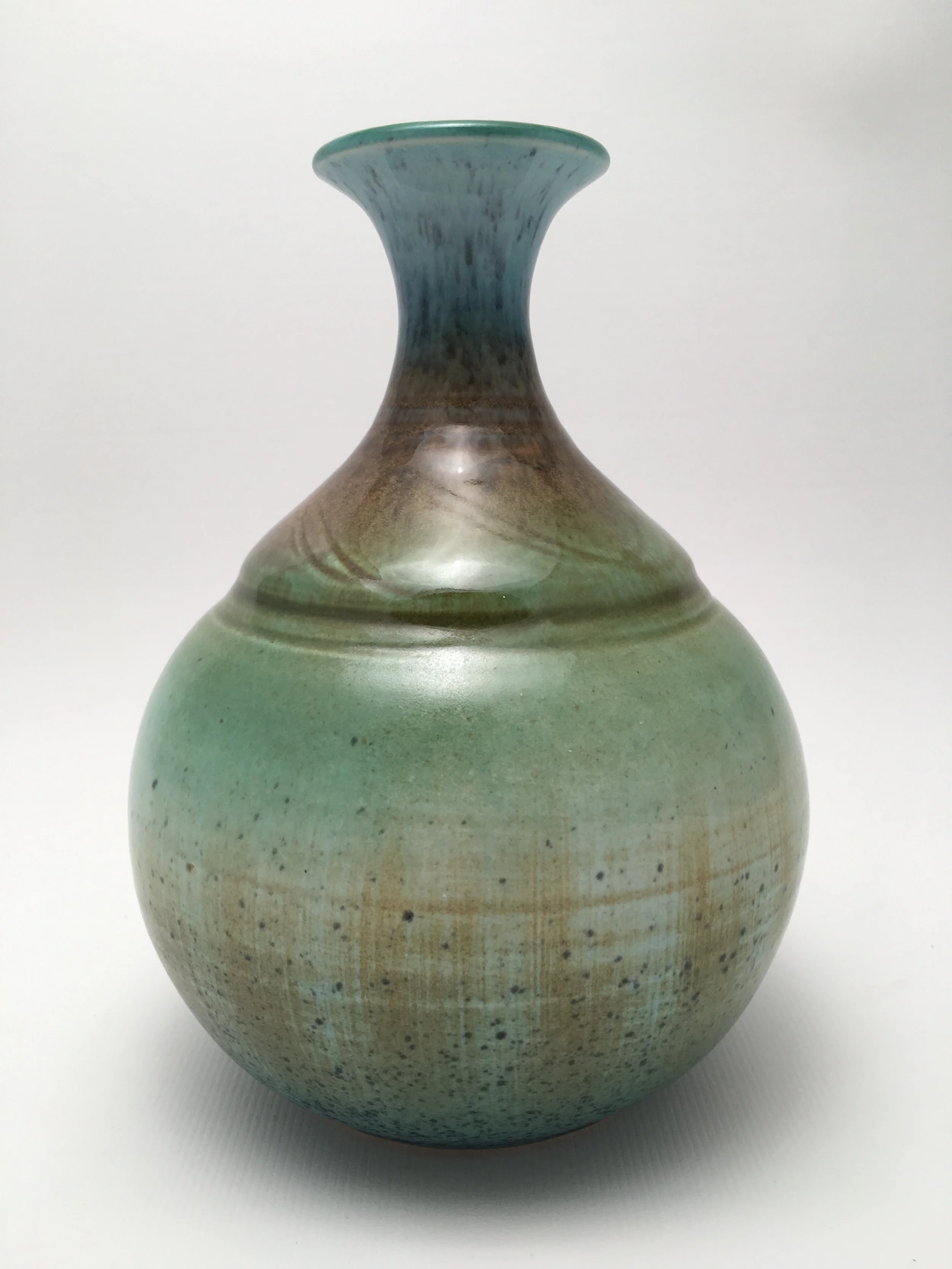 Ceramic vase with a rounded body and a narrow neck, glazed in shades of green, blue, and brown with a speckled finish.