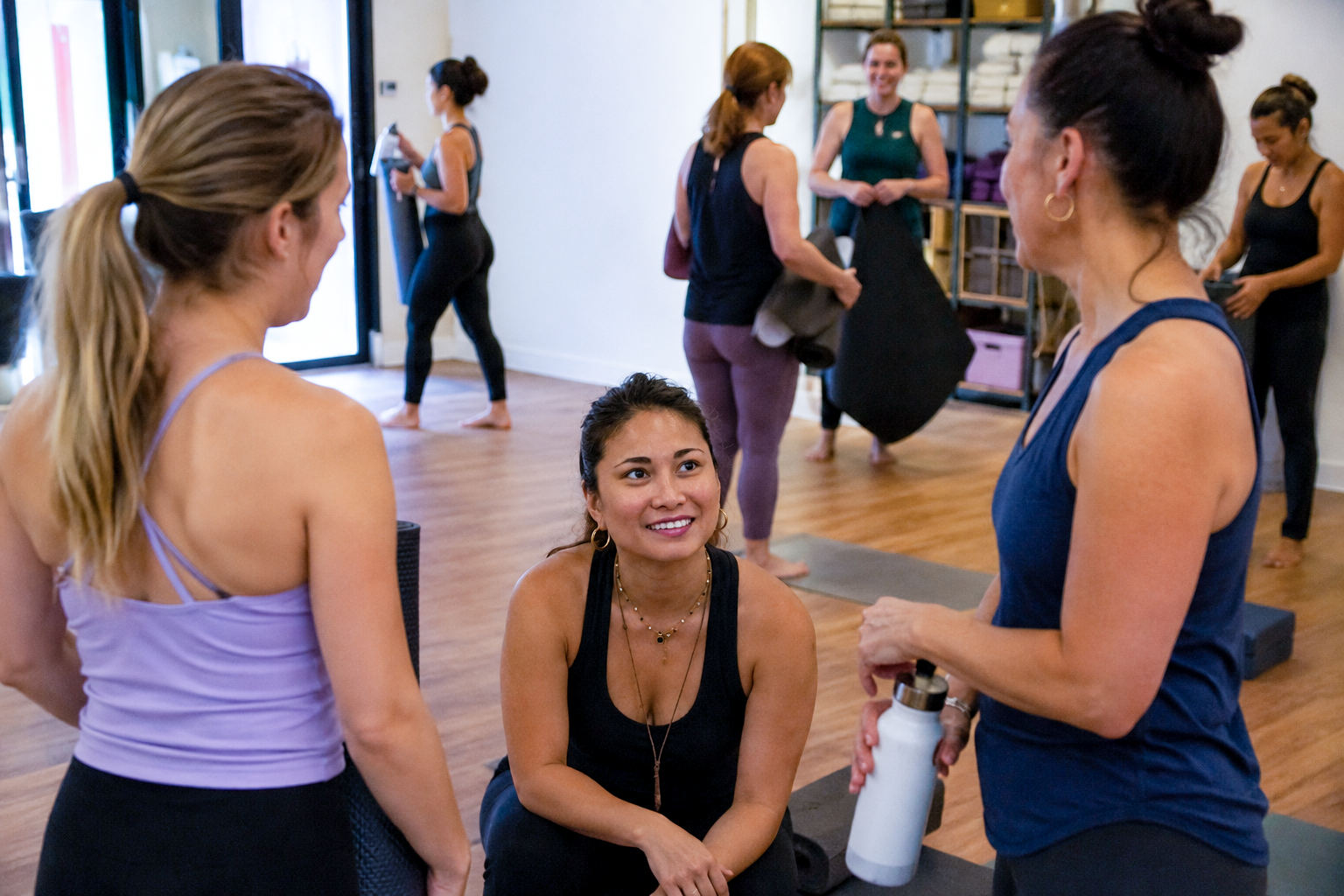 yoga teacher talking to students and connecting after a yoga class