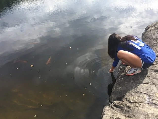 Grace trying to feed the fish.