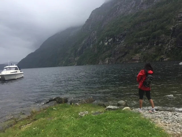 Grace throwing rocks in the fjord.