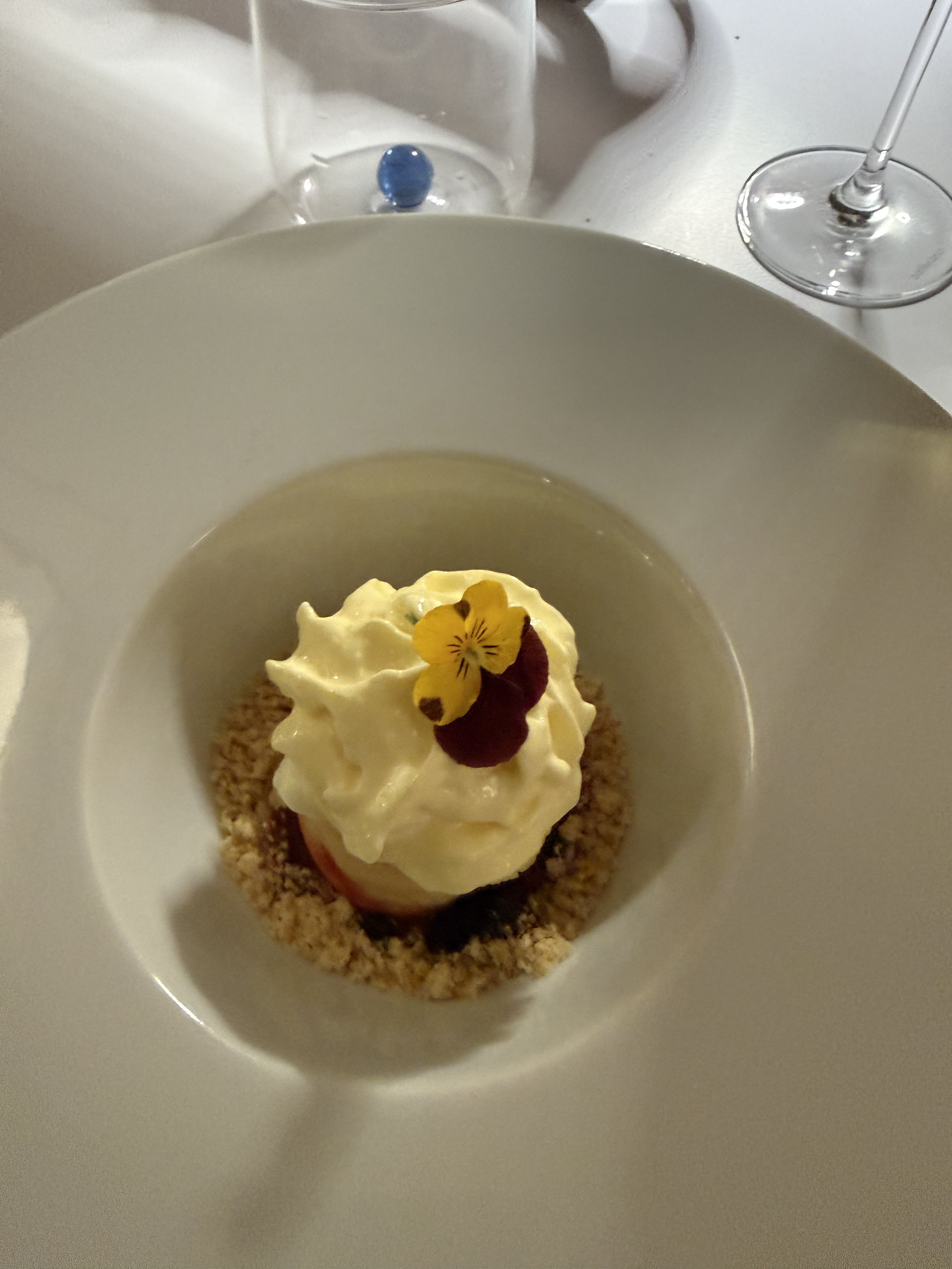 Creamy Lemon dessert on berry sauce with a froth of lemoncello.