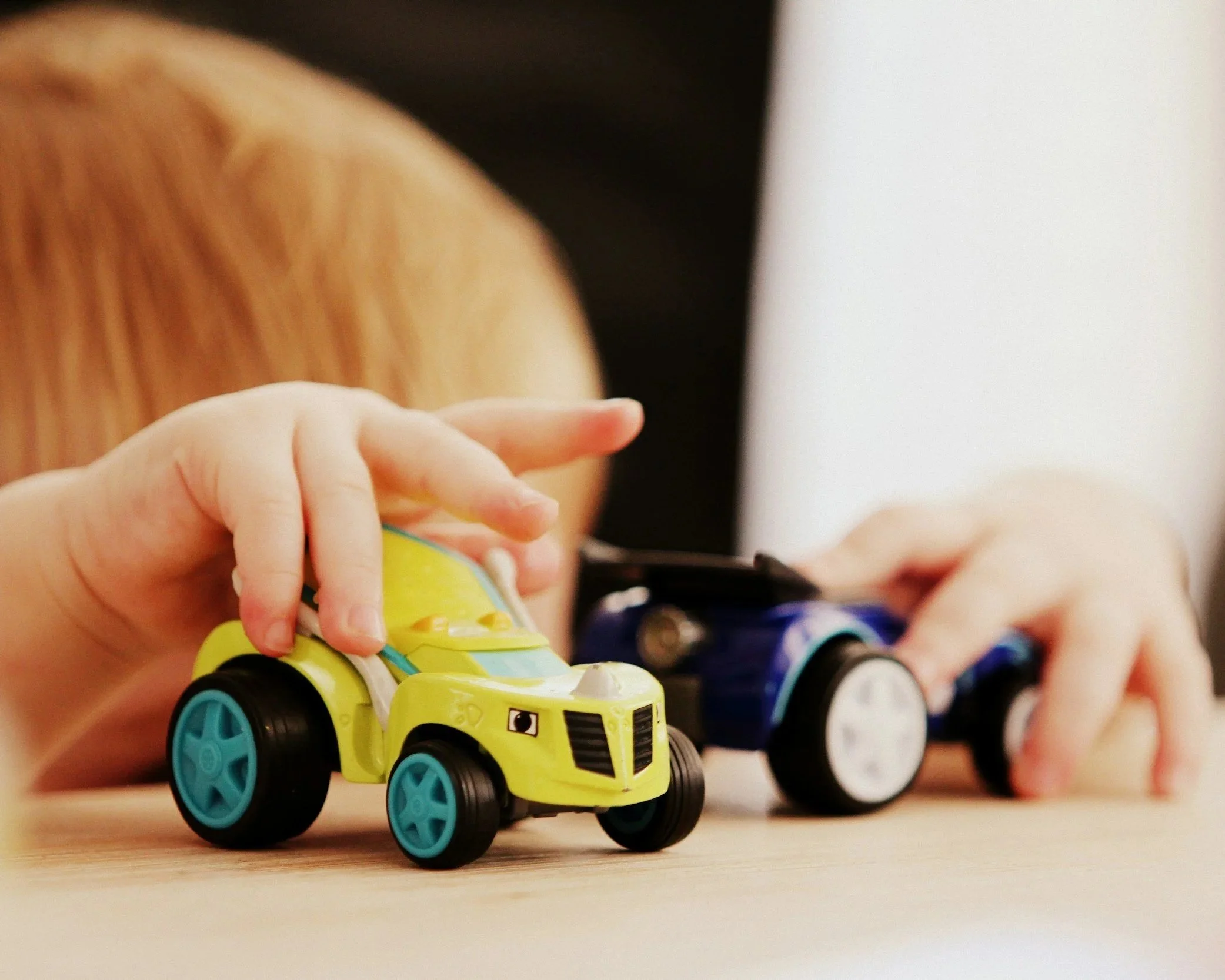 Toddler boy playing cars during speech therapy with New Leaf Speech Services in Cedar Park TX