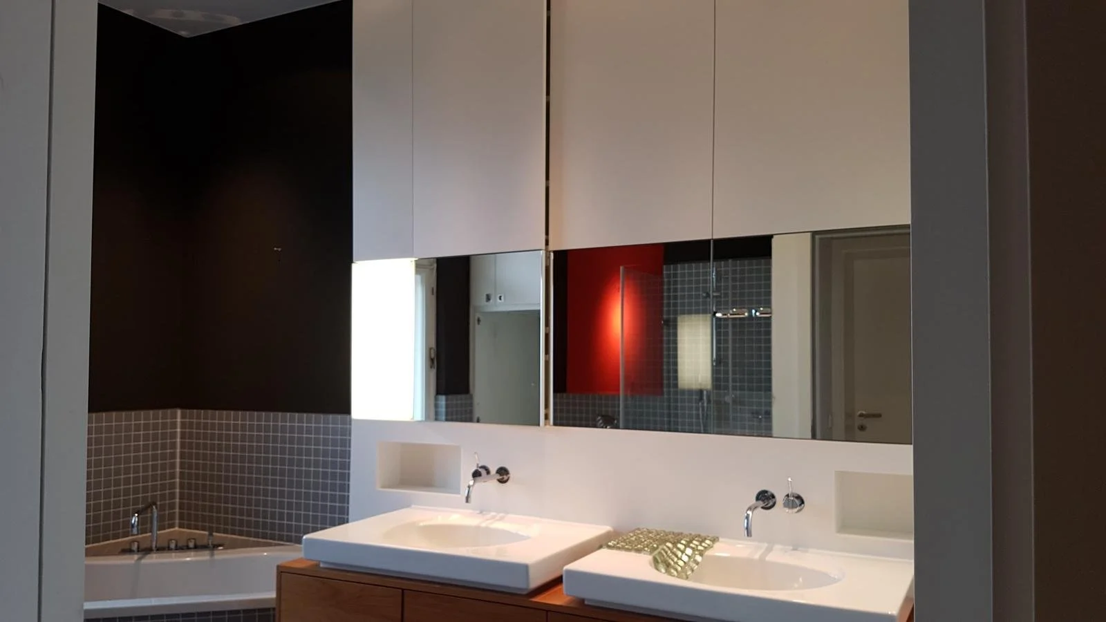 Modernes Badezimmer mit Doppelwaschbecken, Spiegel, dunklen Fliesen und Badewanne Projektentwicklung Berlin