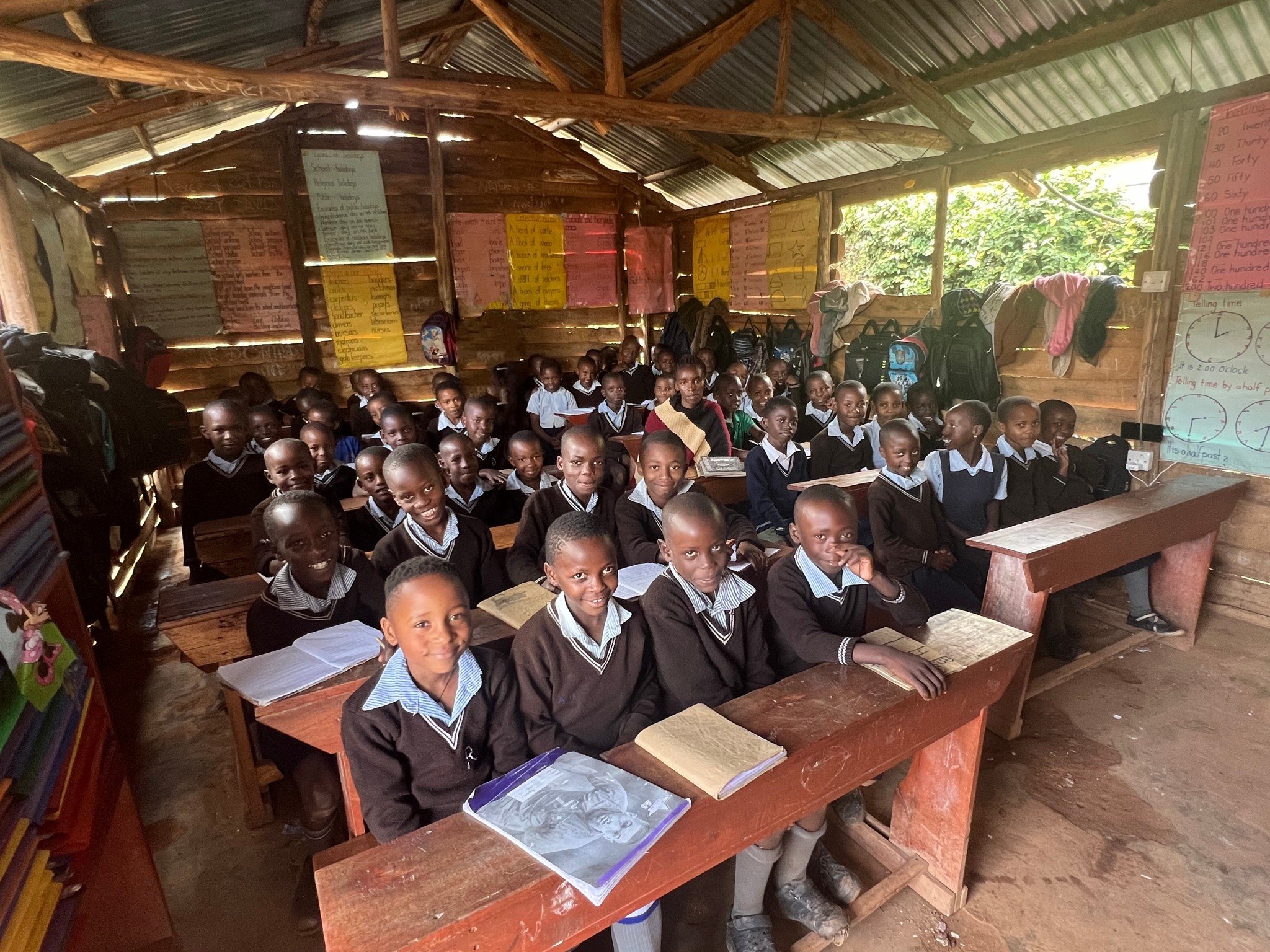 Smiling children at Amatsiko Preparatory School in Uganda expressing joy and hope during their education journey.