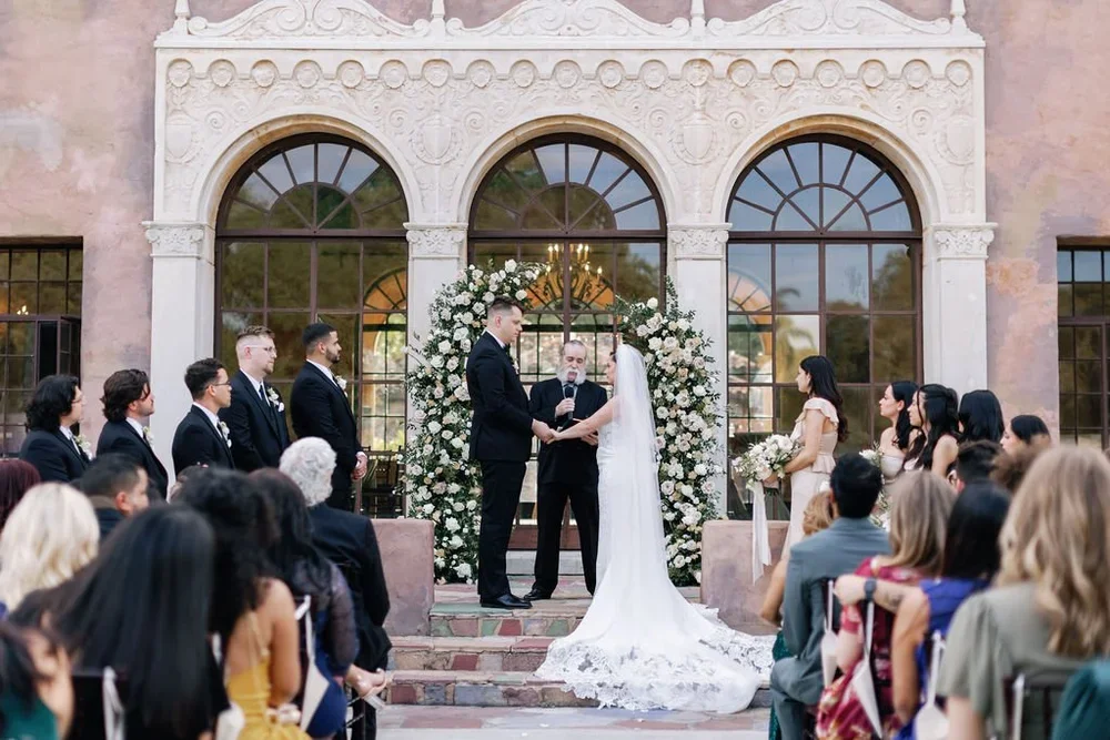 Wedding ceremony in front of the arched windows of the Howey Mansion in Howey-in-the-Hills, Florida