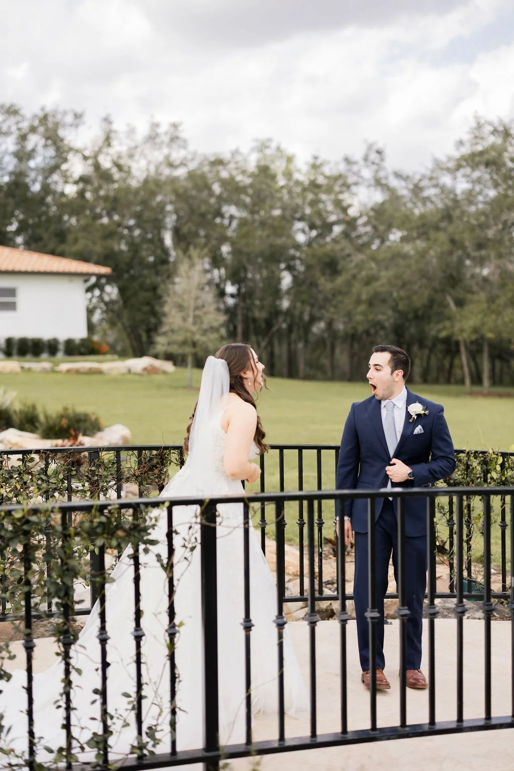 Groom sees his bride for the first time during an outdoor wedding first look at a Florida wedding venue