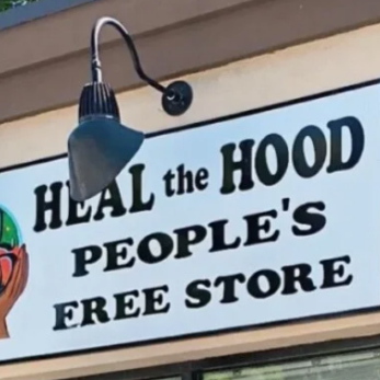 Store sign reading 'Heal the Hood People's Free Store' with a black lamp above the sign.