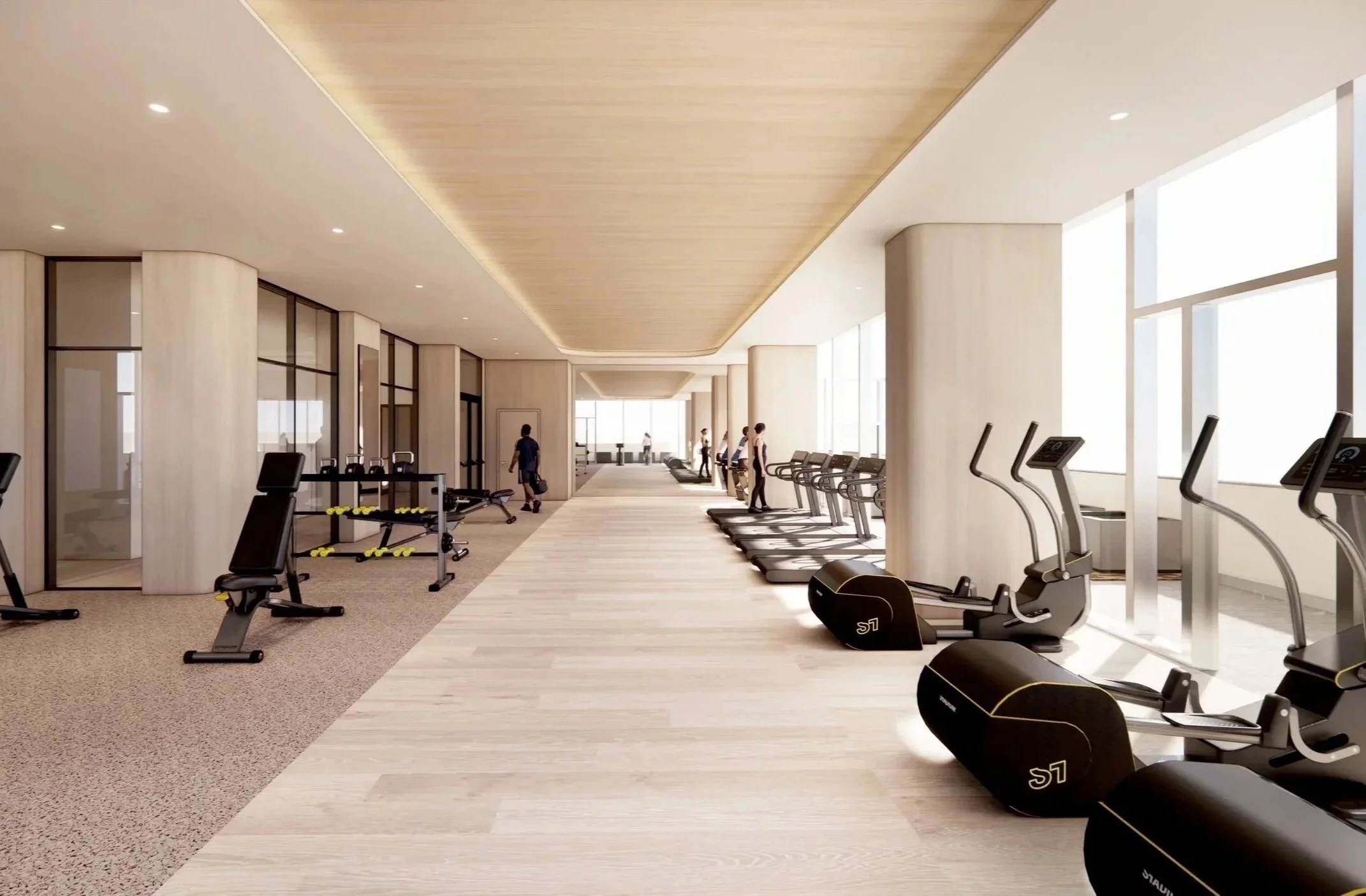 Modern gym with cardio equipment such as treadmills and exercise bikes, large windows, and a few people exercising during the daytime.
