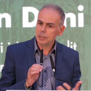 Portrait of a man outdoors with trees in the background.