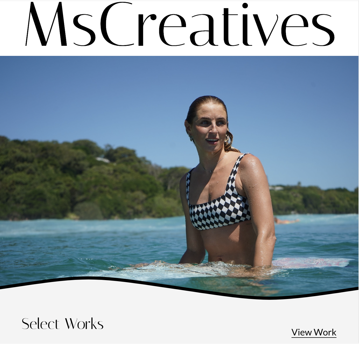 A woman in a checkered swimsuit swimming in the ocean with a green island and blue sky in the background, on a magazine cover titled 'MsCreatives'.