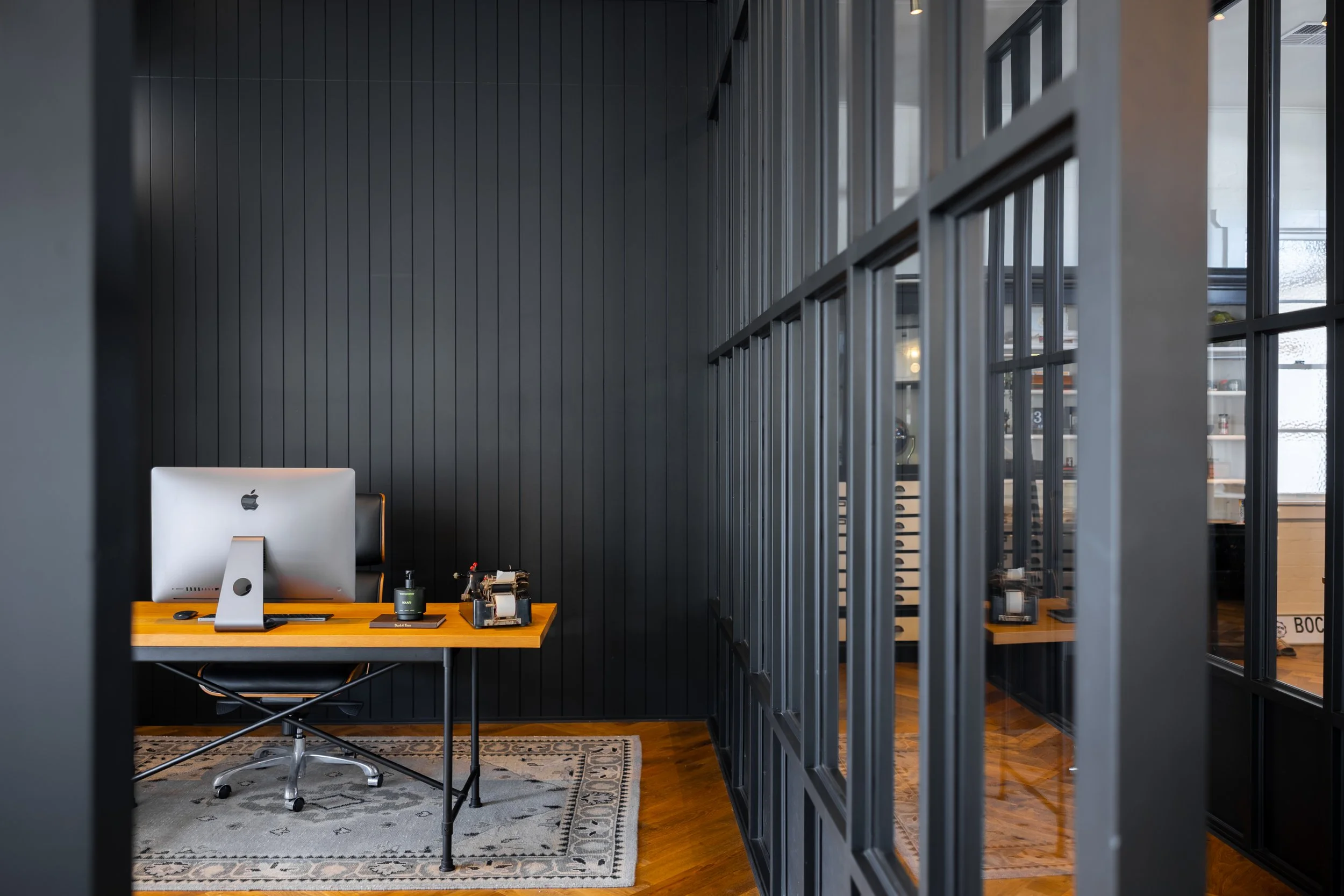 Modern office with apple computer and glass windows located in Brisbane City.