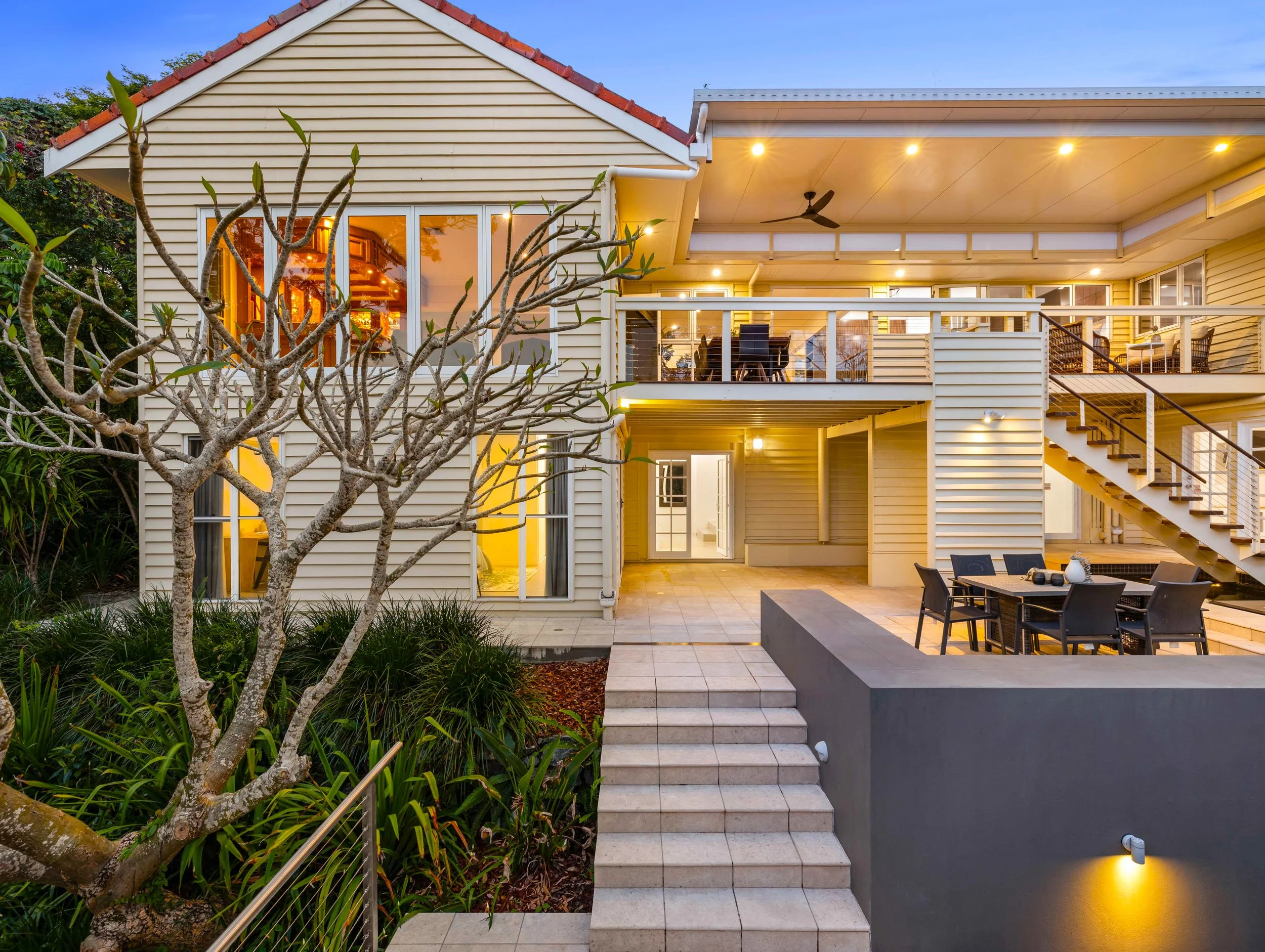 Large historical home shot in dusk with large tree in front of home located in Brisbane City.