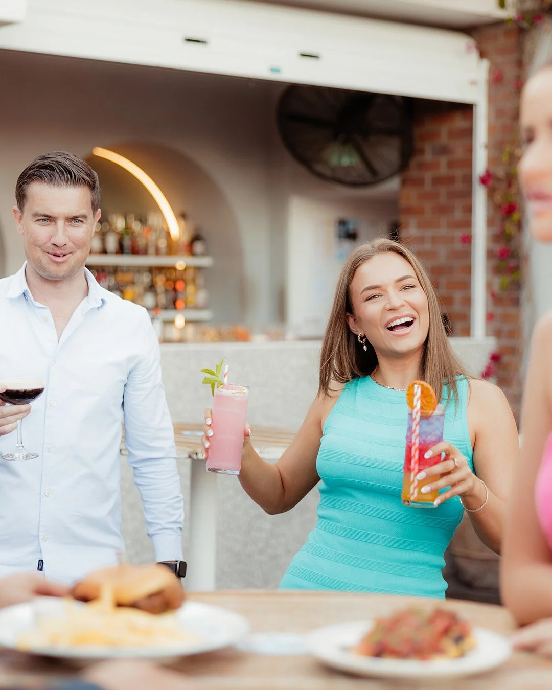 Young female smiling with drinks in her hand at Everton Park Plaza. 