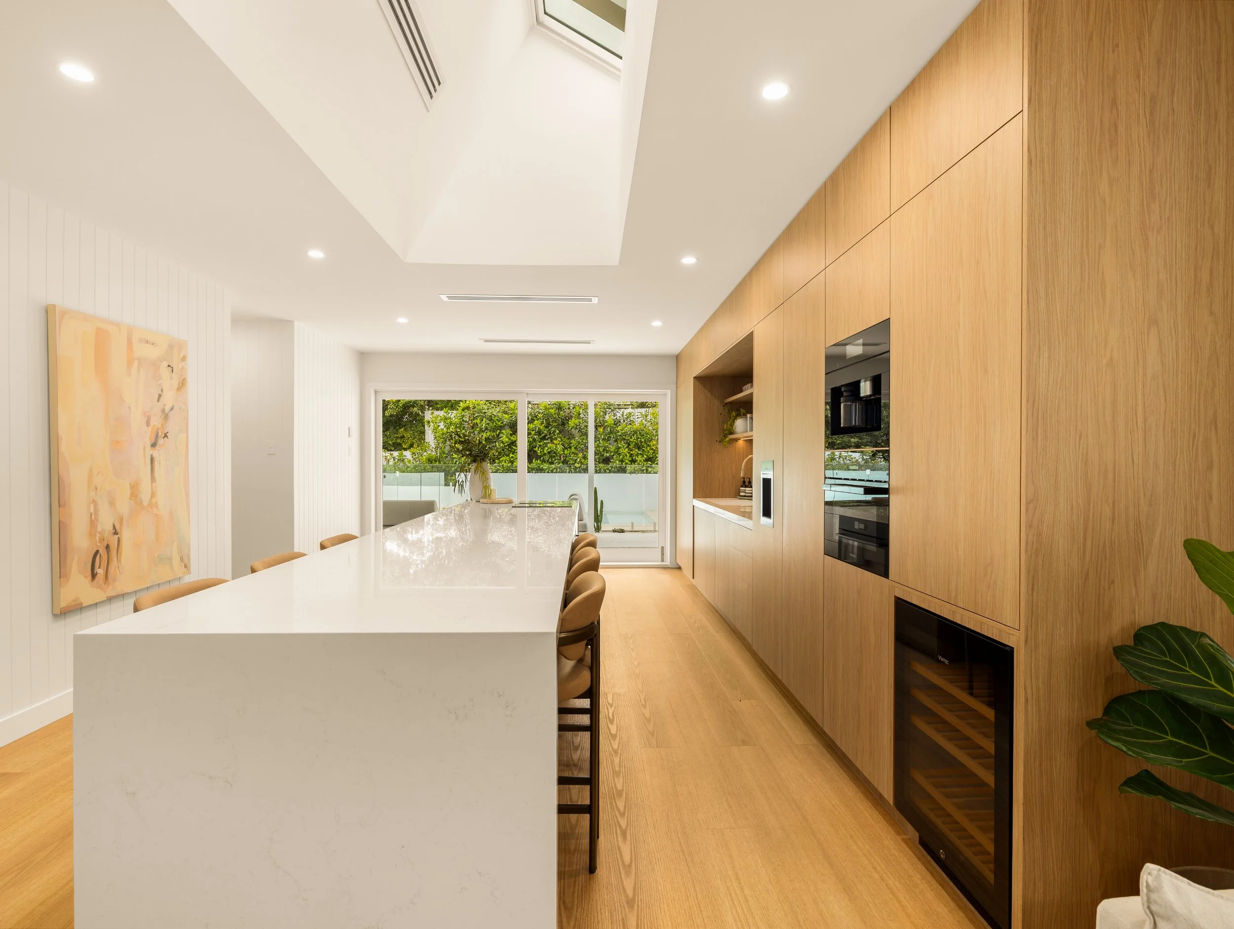Large modern kitchen in Brisbane with a large stone benchtop and warm colour palette. 