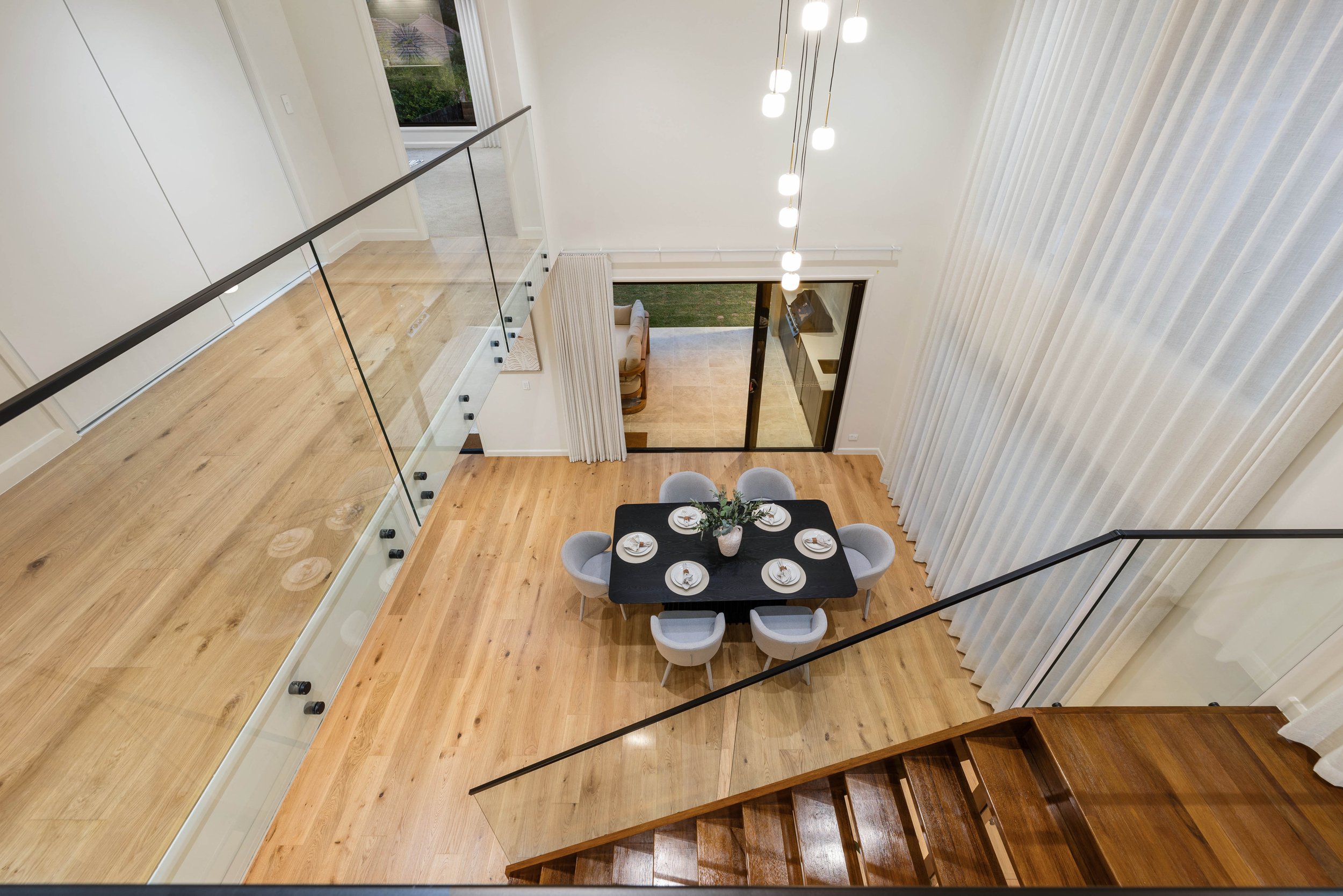 Luxury staircase overlooking a modern large dining room in Brisbane City.