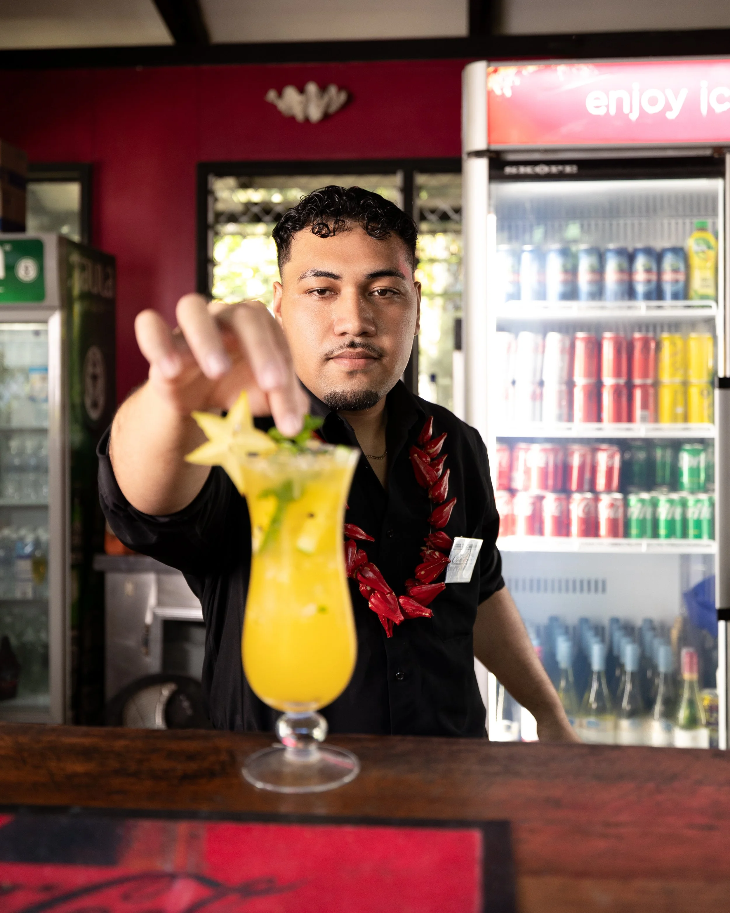 Bartender garnishing cocktail at Orator Hotel Samoa.