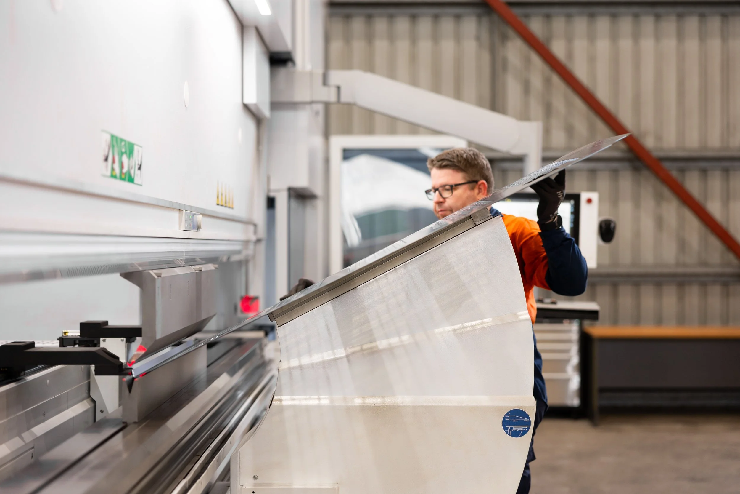 Grydale manufacturing worker bending a large flat piece of steel used in units Brisbane.