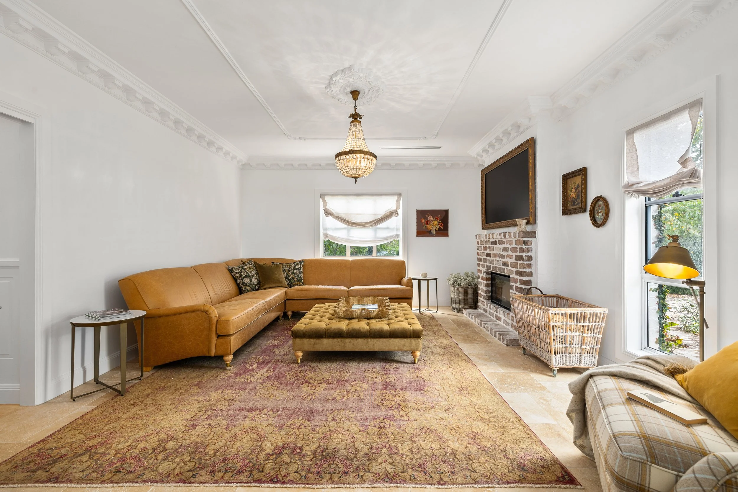 European styled living room with a large fireplace made out of recycled bricks in Gold Coast.