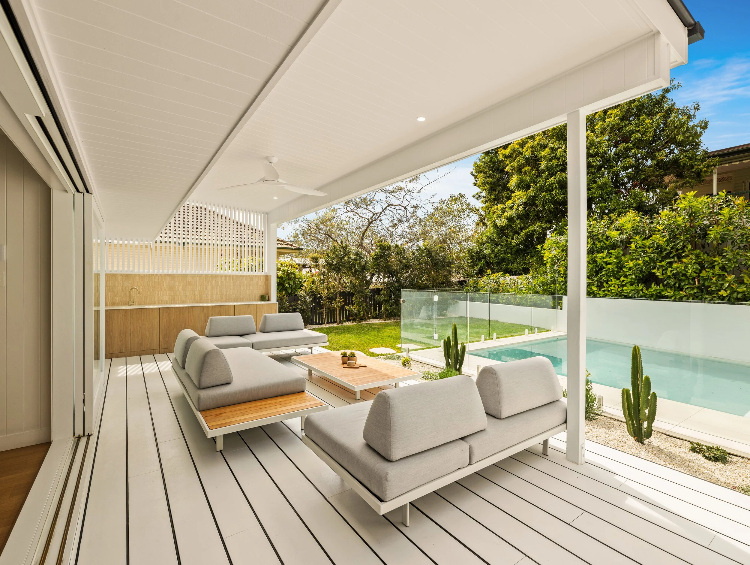 Modern luxury outdoor patio with pool and outdoor furniture overlooking the backyard in Brisbane City. 