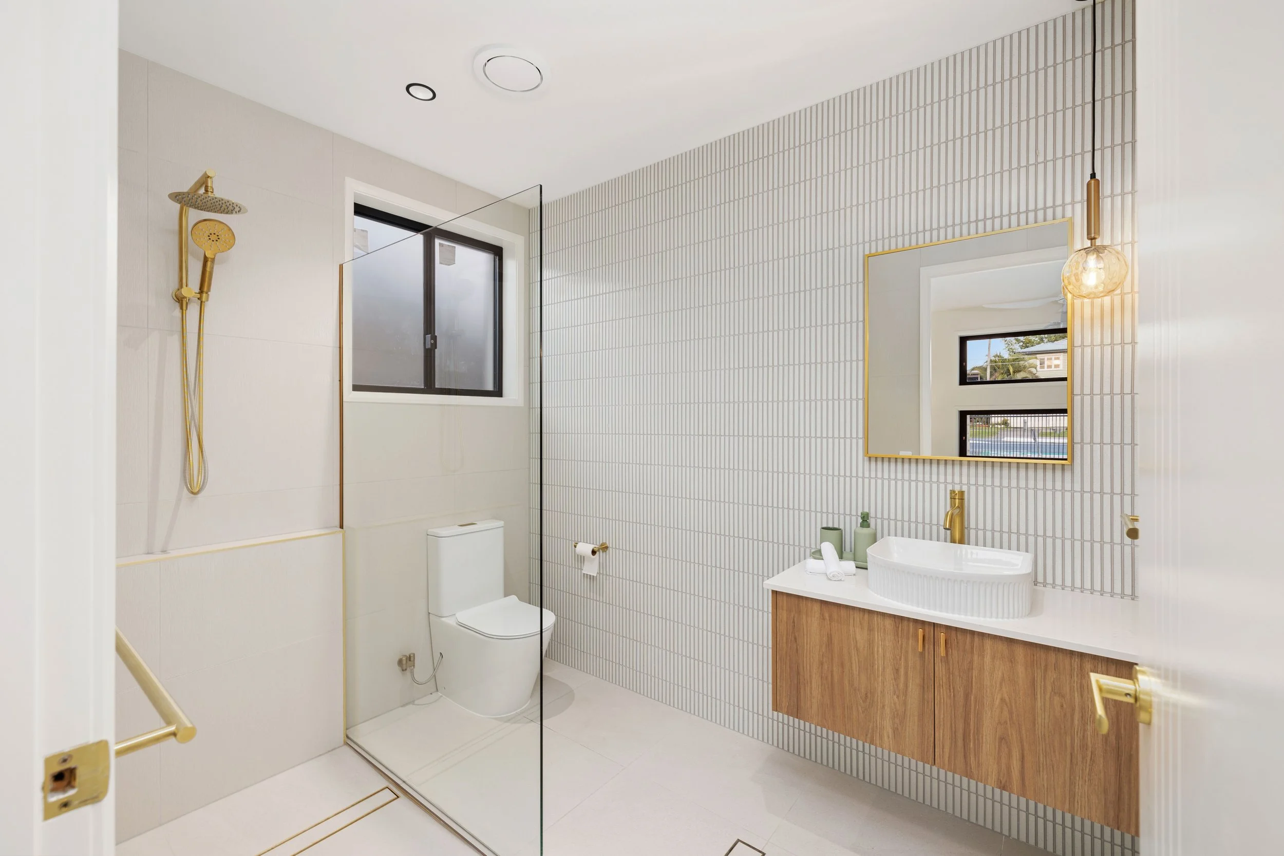 Modern bathroom with modern accessories and warm lighting in Brisbane City.
