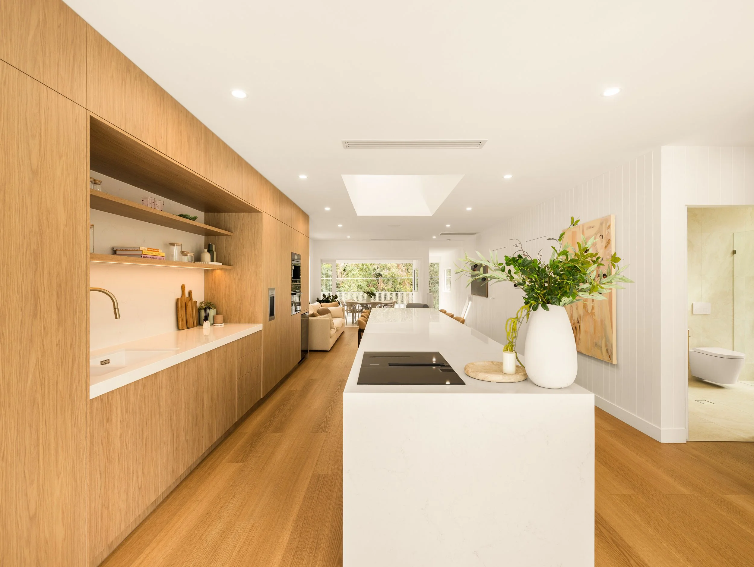 Large luxury kitchen with modern cabinetry and oversized stone bench top. 