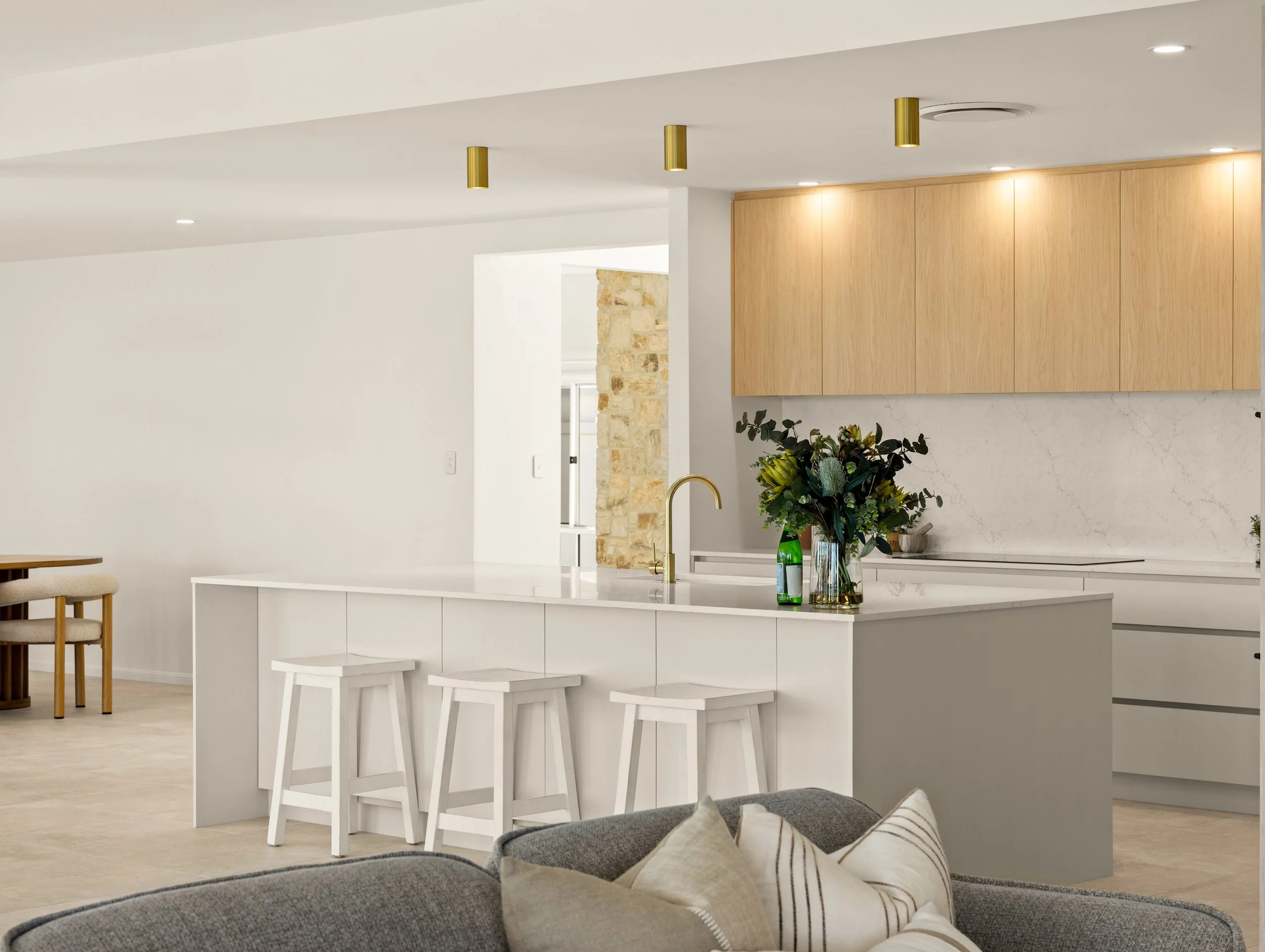 Luxury kitchen with large bench top and gold tapware and modern cabinetry located in Brisbane City.