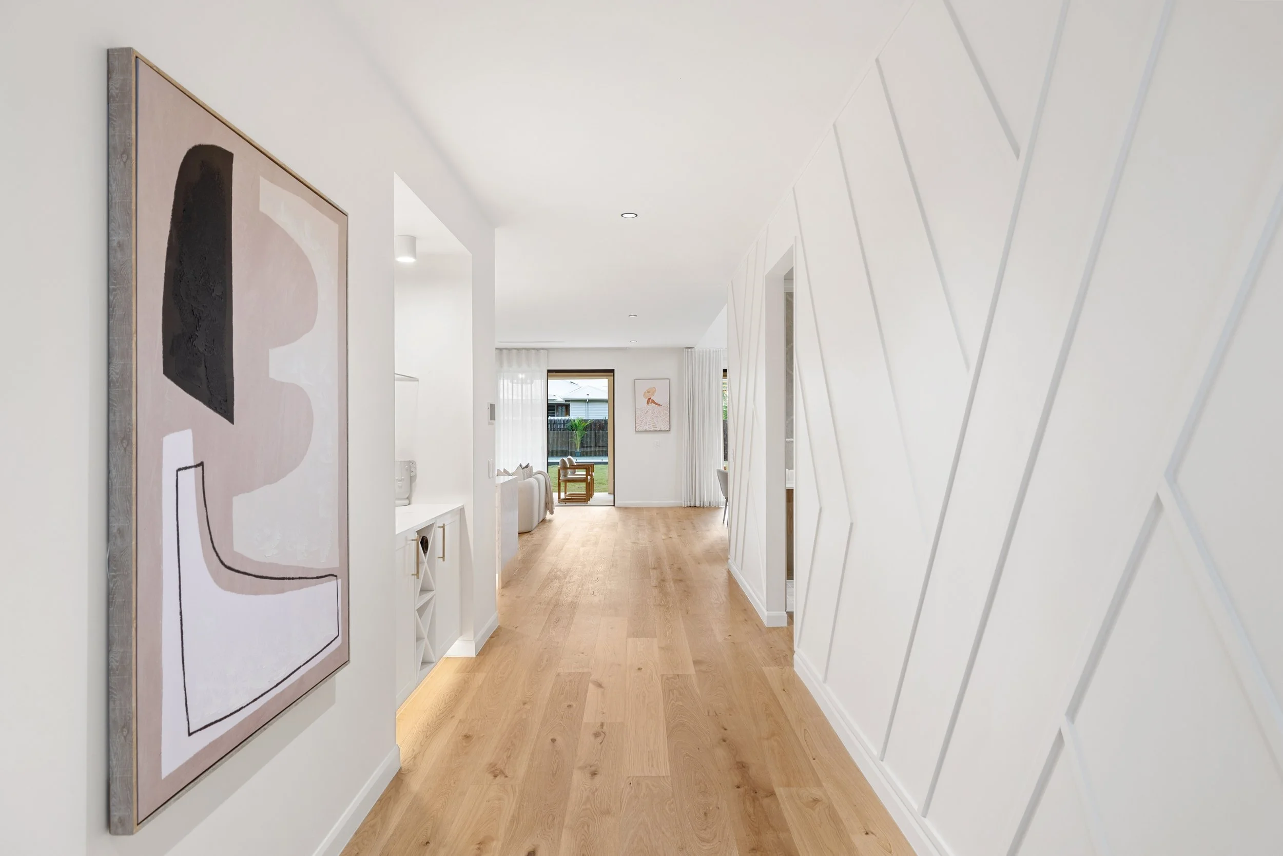 Modern hallway with abstract painting, textured walling and wooden flooring located in Brisbane City. 