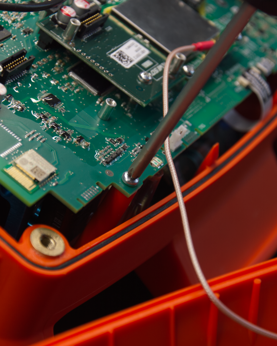 Indvendigt i en elektronisk enhed med printkort, stik og kredse.