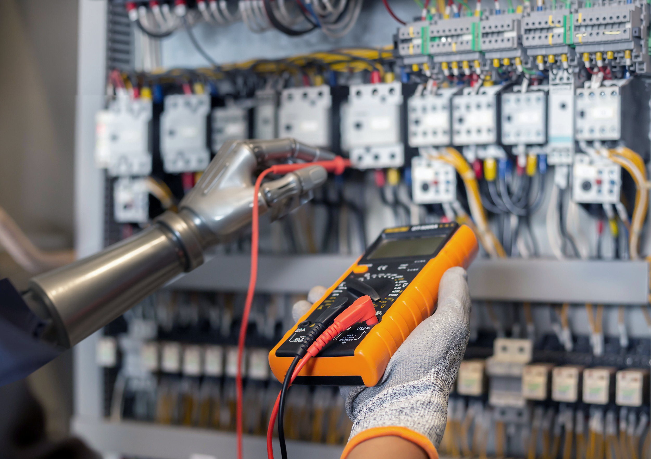 A robot uses a multimeter to inspect mechanical, electrical, and plumbing equipment inside a building, symbolizing the need for software that connects AI insights to real maintenance work.