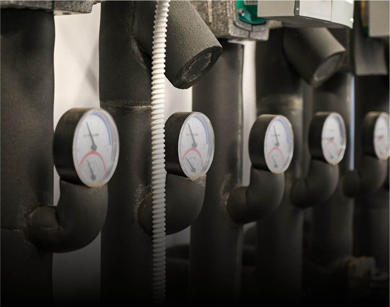 Plusieurs tuyaux noirs munis de manomètres, reliés à un système de plomberie.